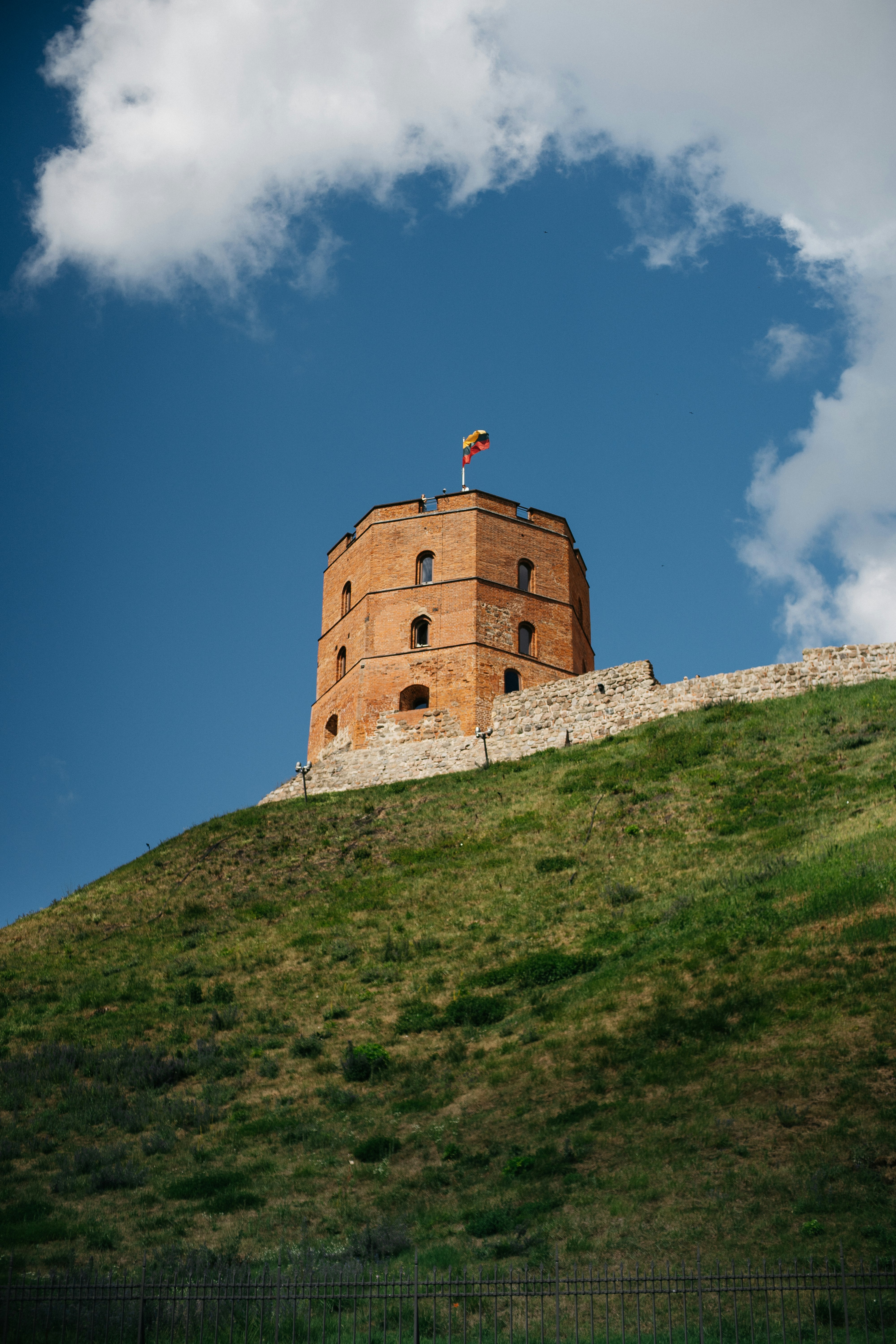 Gediminas' tower sits atop a green hill.