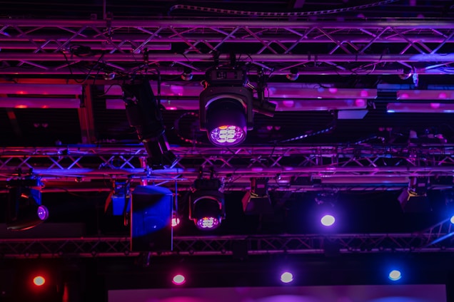 Stage lights illuminating a colorful event space.