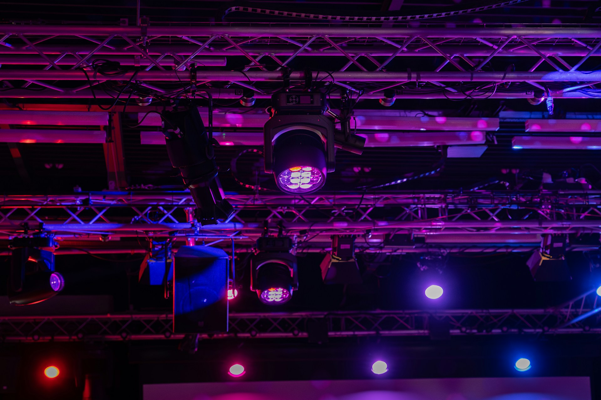 Stage lights illuminating a colorful event space.