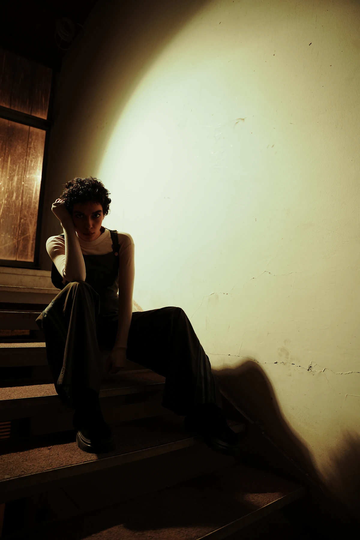 Person sitting alone on stairs, deep in thought — representing the anticipatory, internal nature of anxiety