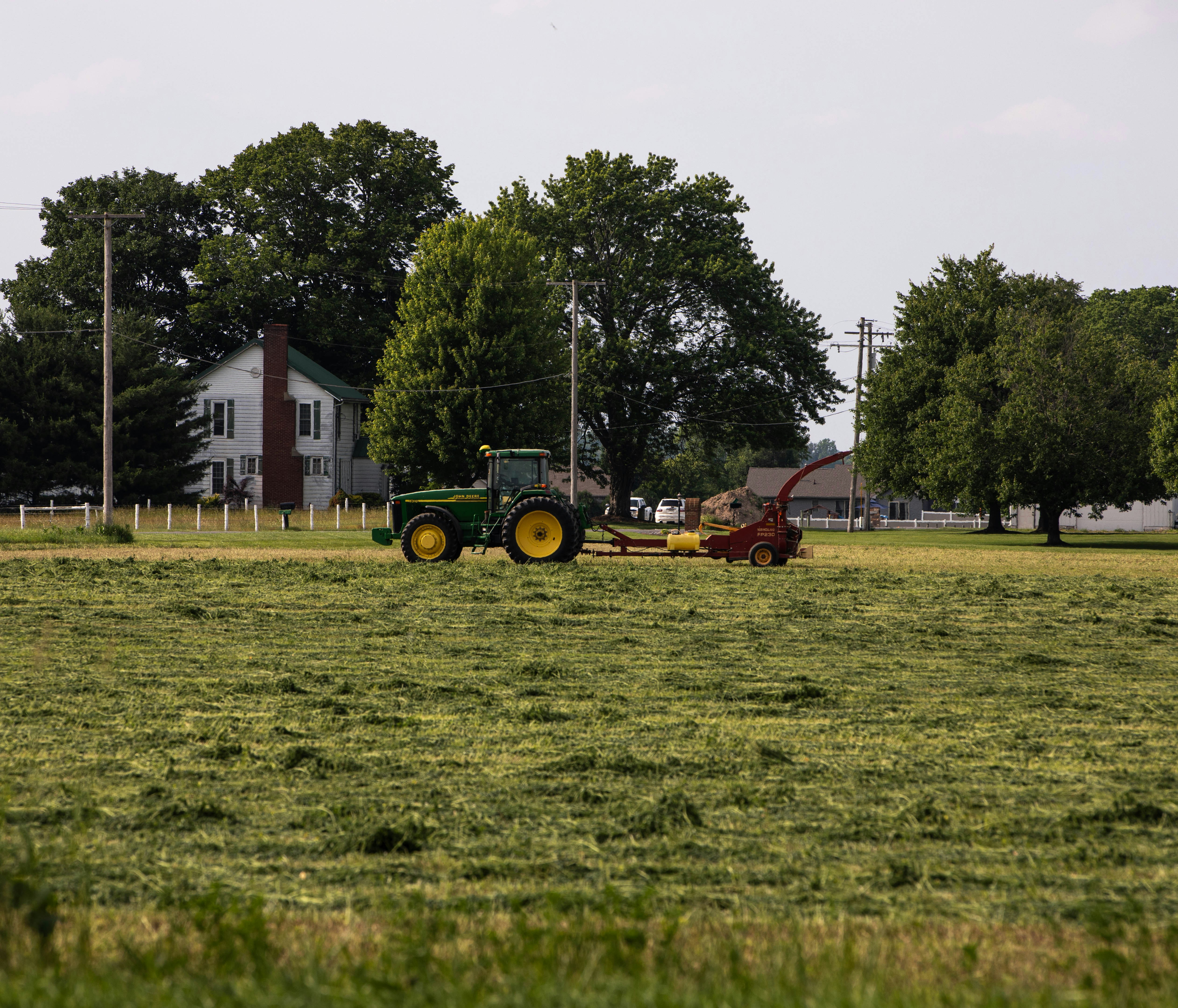A tractor is working in a green field.