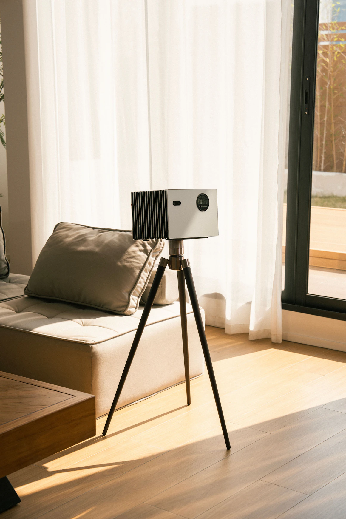 Modern projector on a tripod in a bright living room