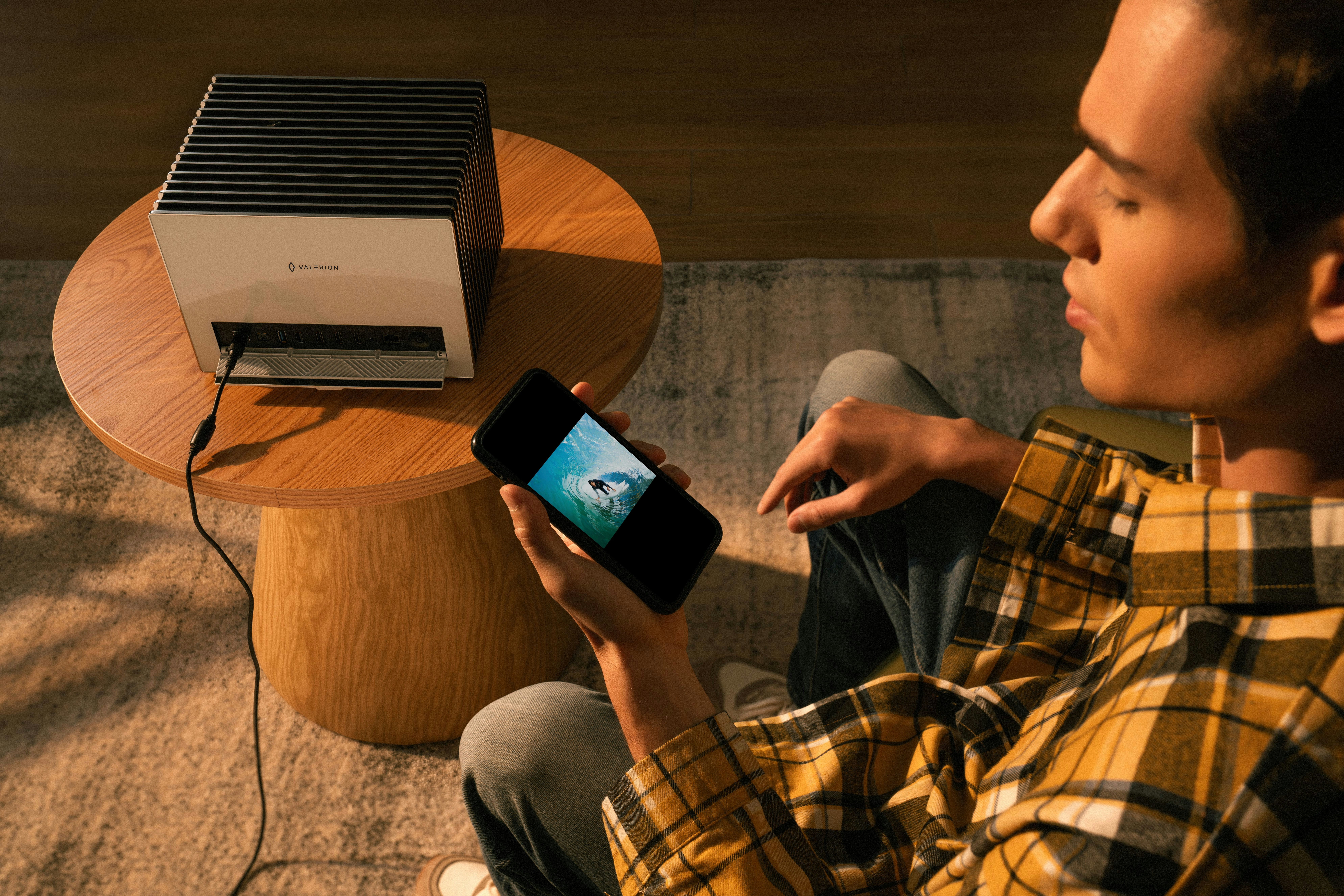 A man uses a phone connected to a projector.