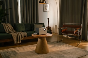 A projector sits on a table in a living room.