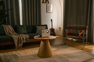 A projector sits on a table in a living room.