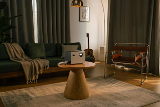 A projector sits on a table in a living room.