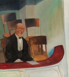 Man in tuxedo at a table with a paper