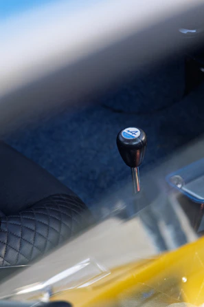 A manual gear shift lever in a car.