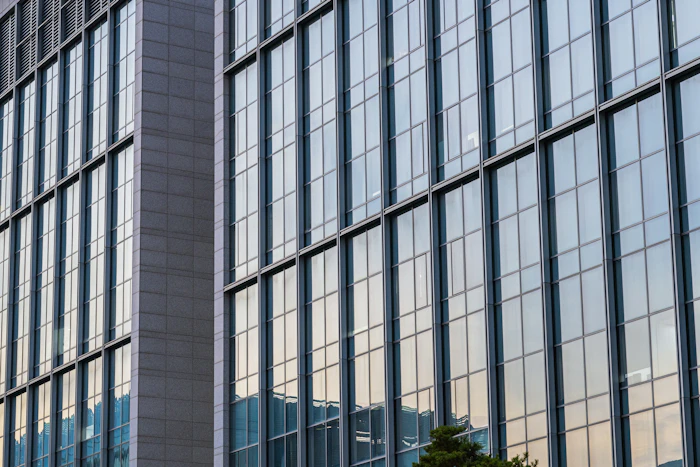 Modern glass office building facade with geometric reflective windows