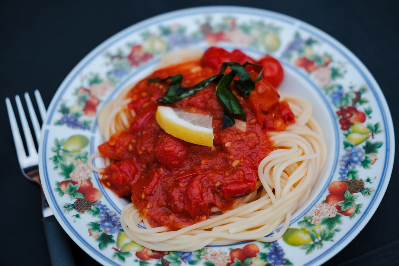 Spaghetti with tomato sauce and lemon on a plate