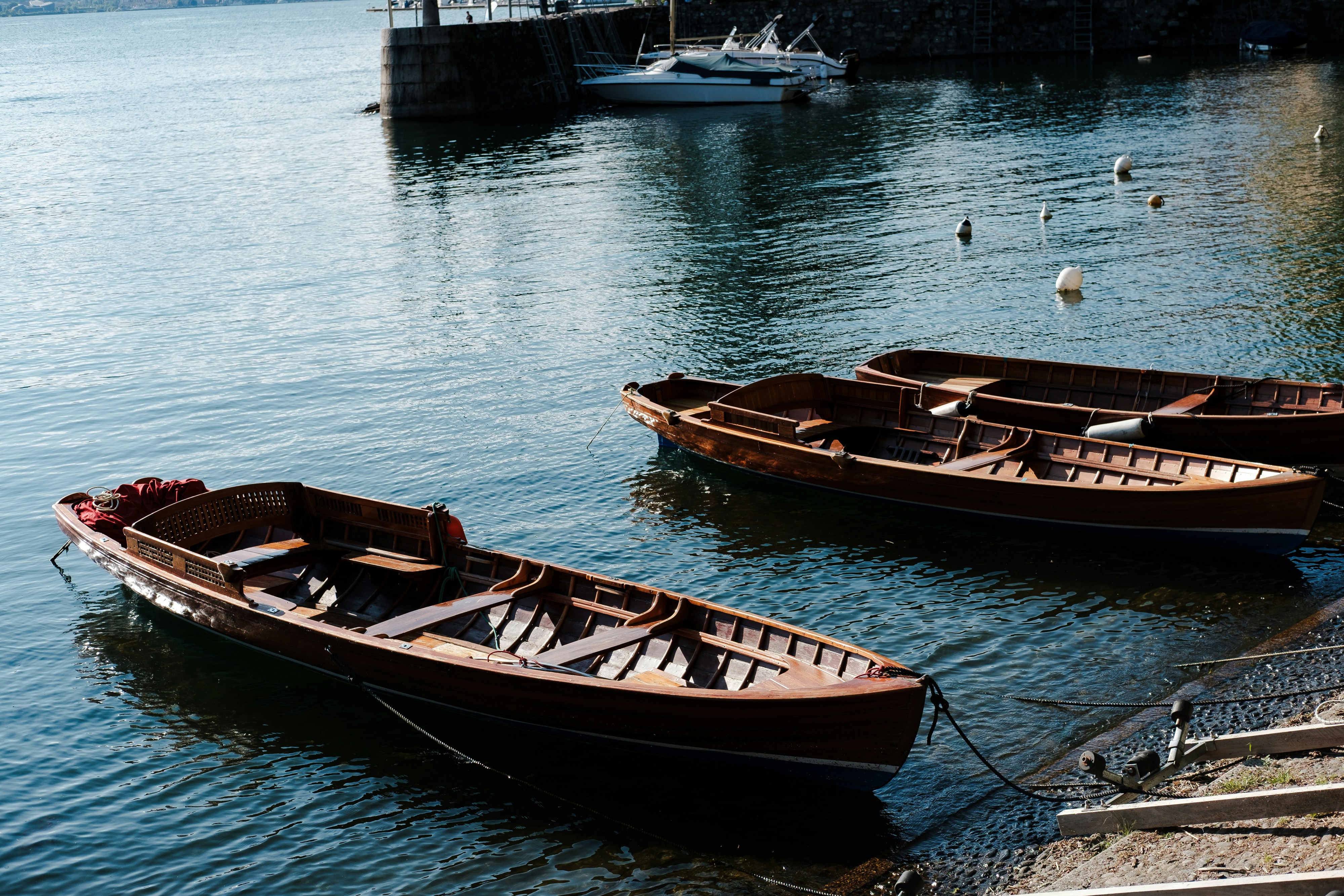 Boats float gently on the calm, blue water.