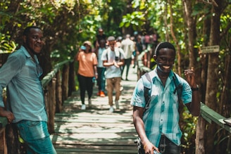 People are walking on a wooden bridge in nature.