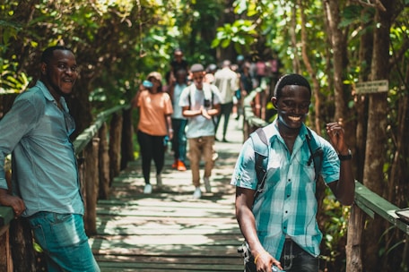 People are walking on a wooden bridge in nature.