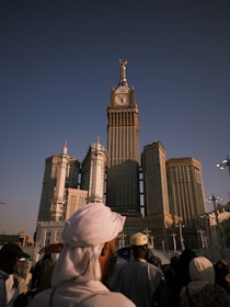 People stand before the abraj al-bait clock tower.