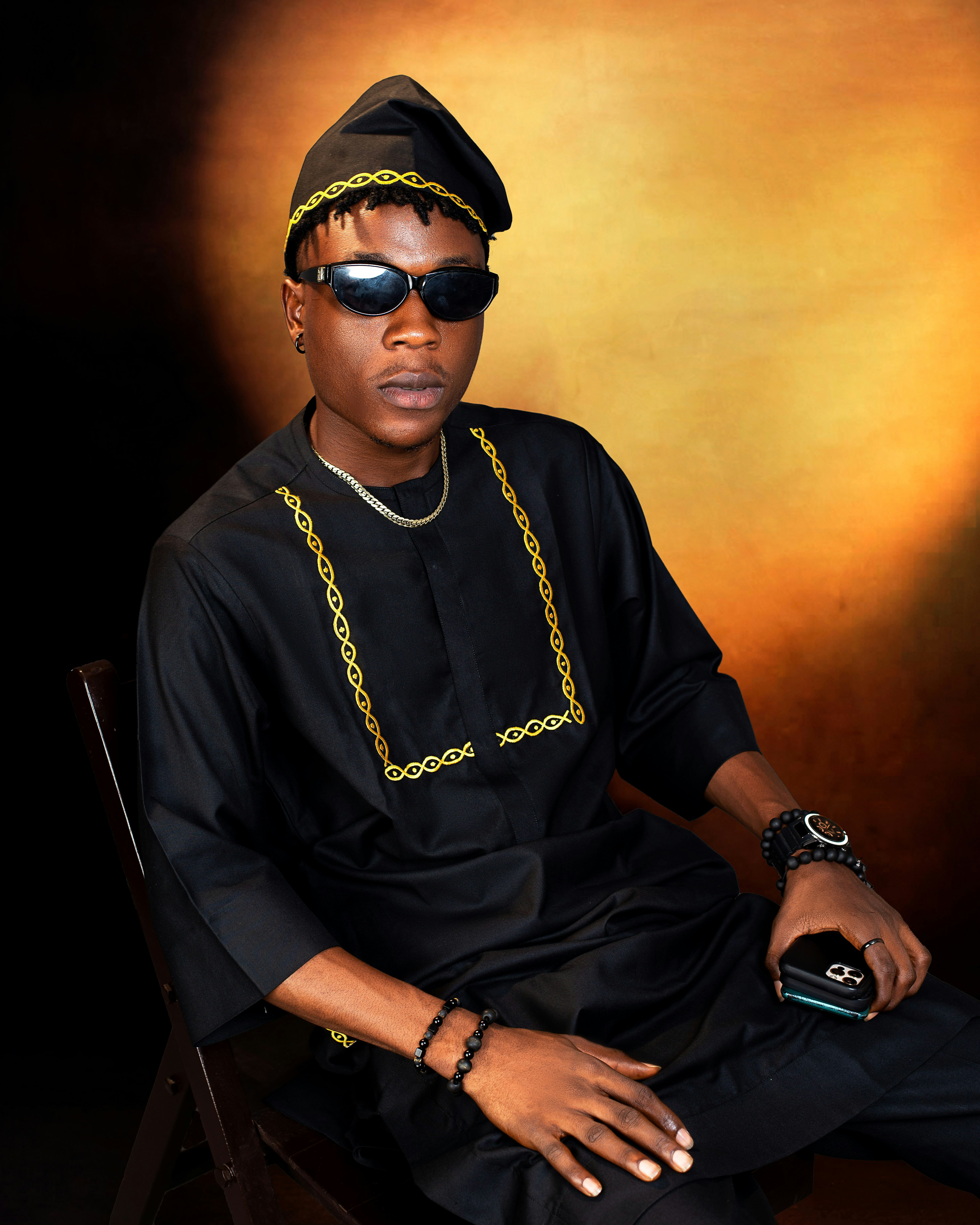 A man in traditional attire poses for a portrait.