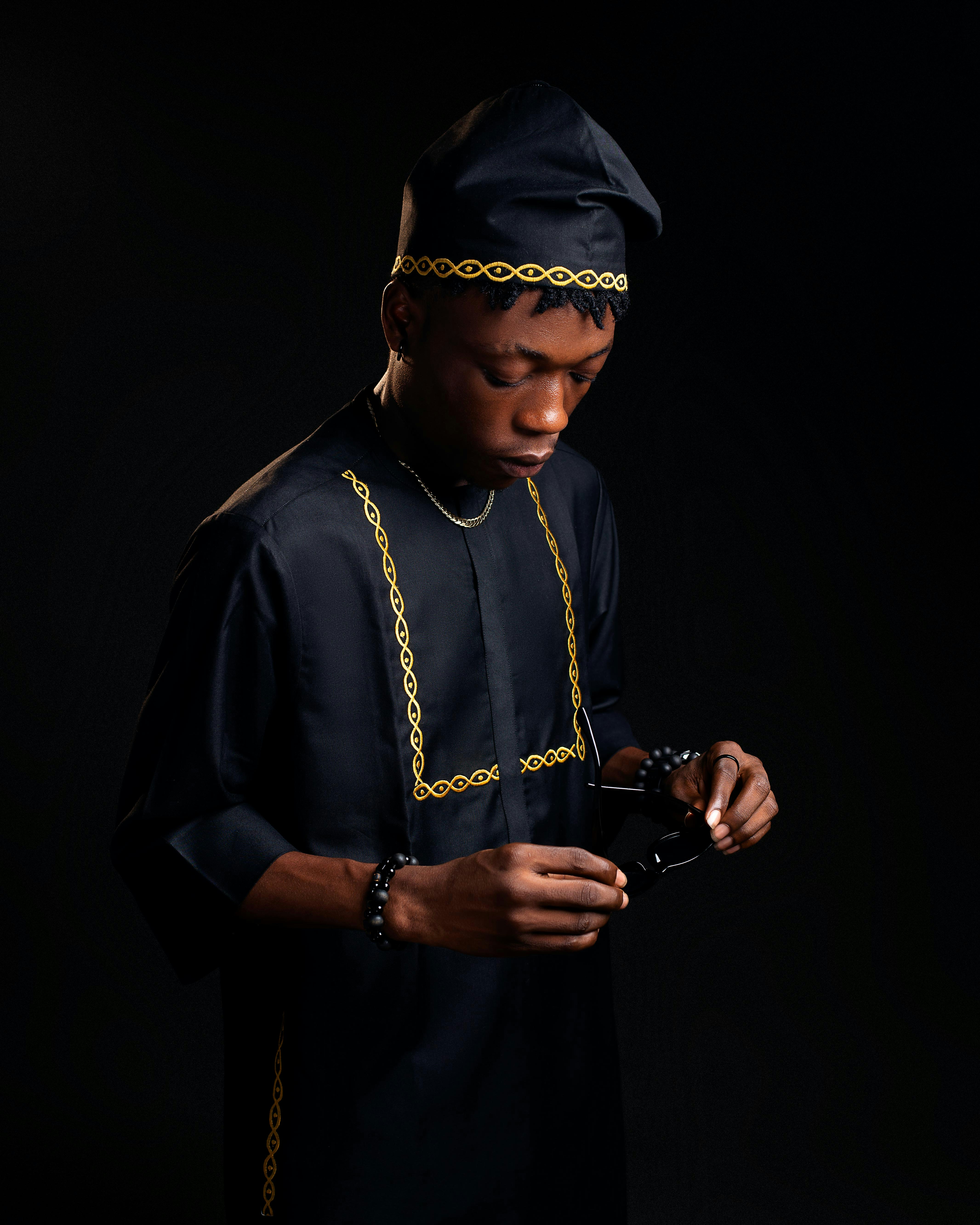 A man in traditional attire looks down.