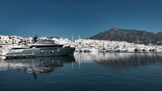 A luxury yacht sits in a beautiful harbor.