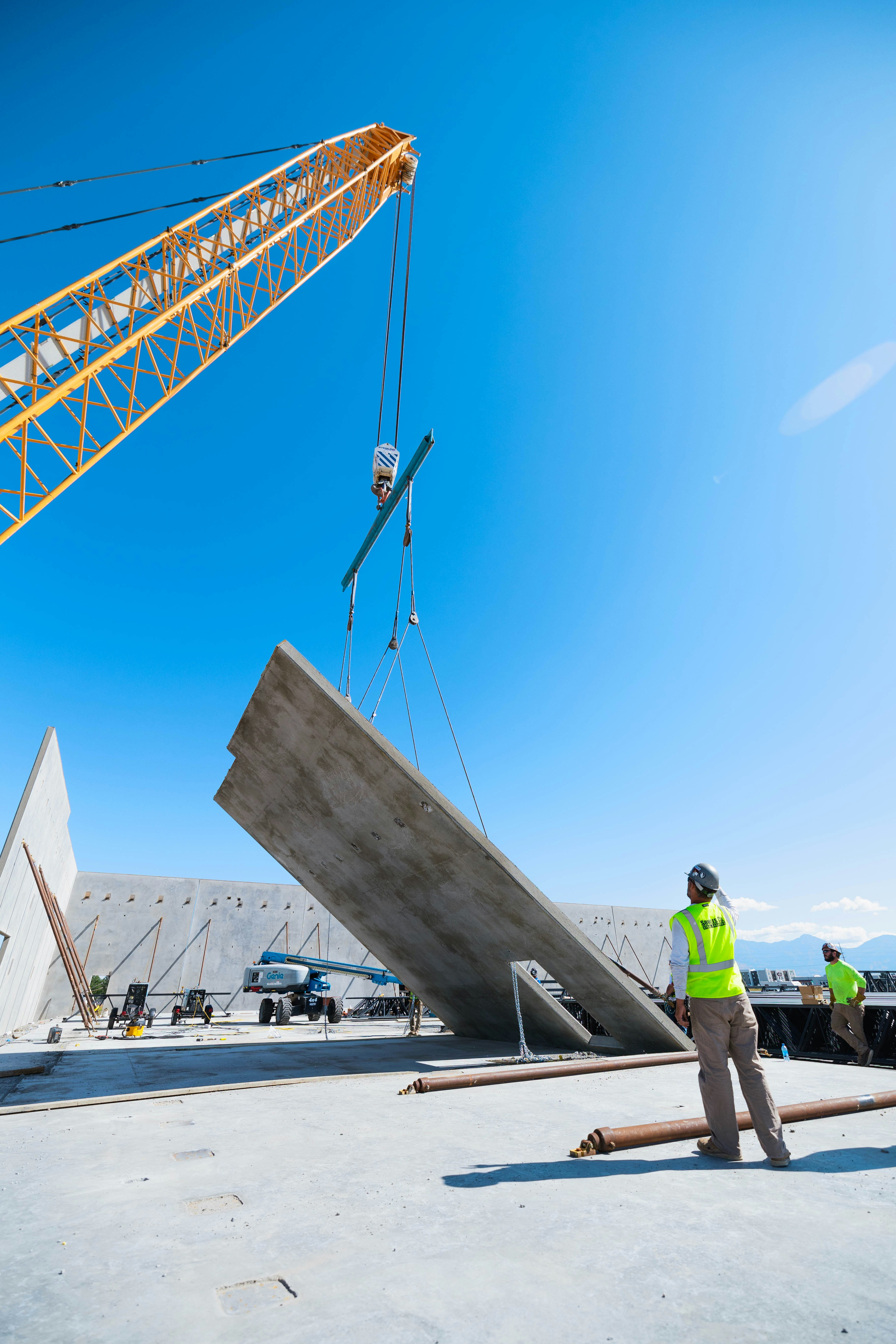 A crane lifts a concrete slab for construction.