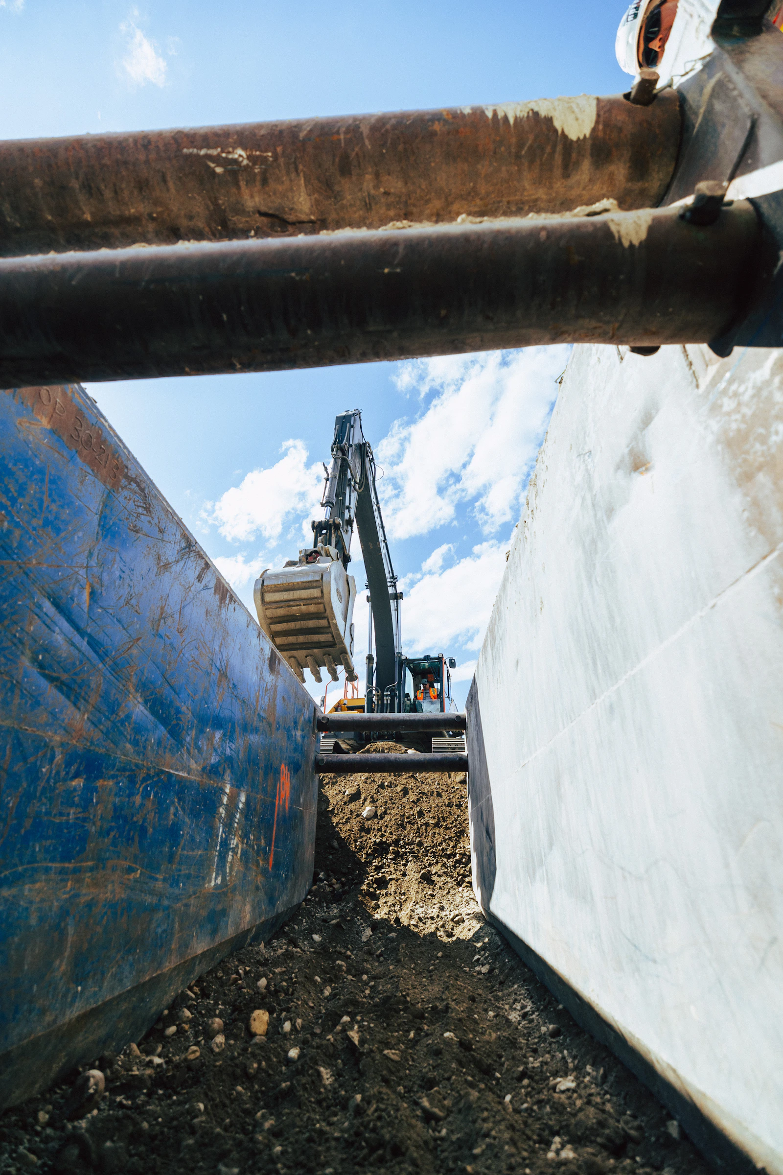 Operator placing a trench box on a prepared utility site