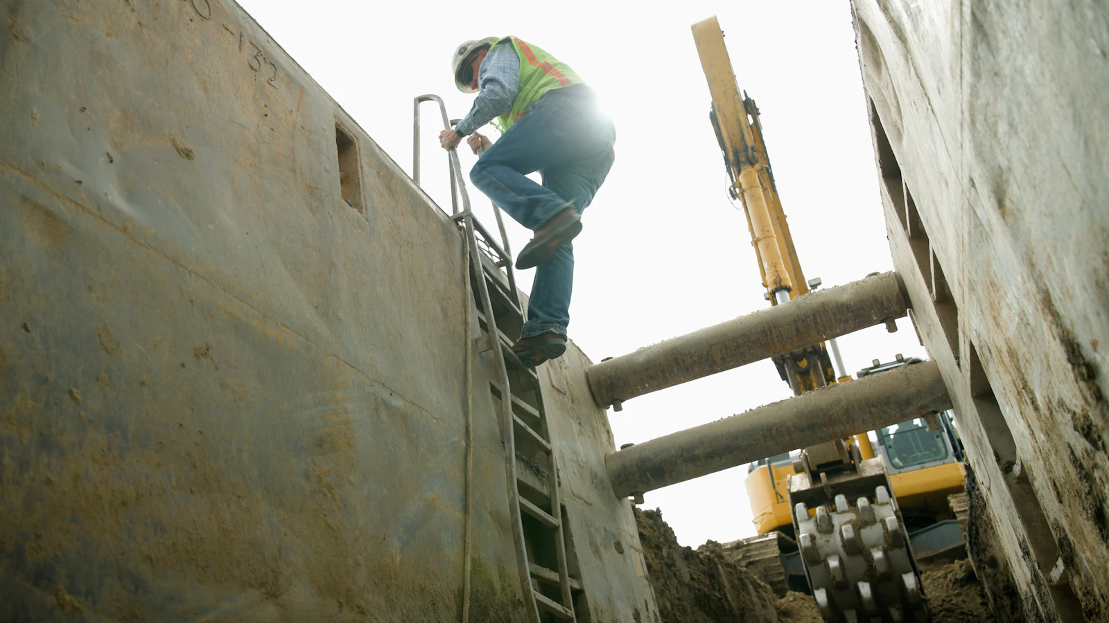 Groundworker in a deep trench box during cable and pipe laying