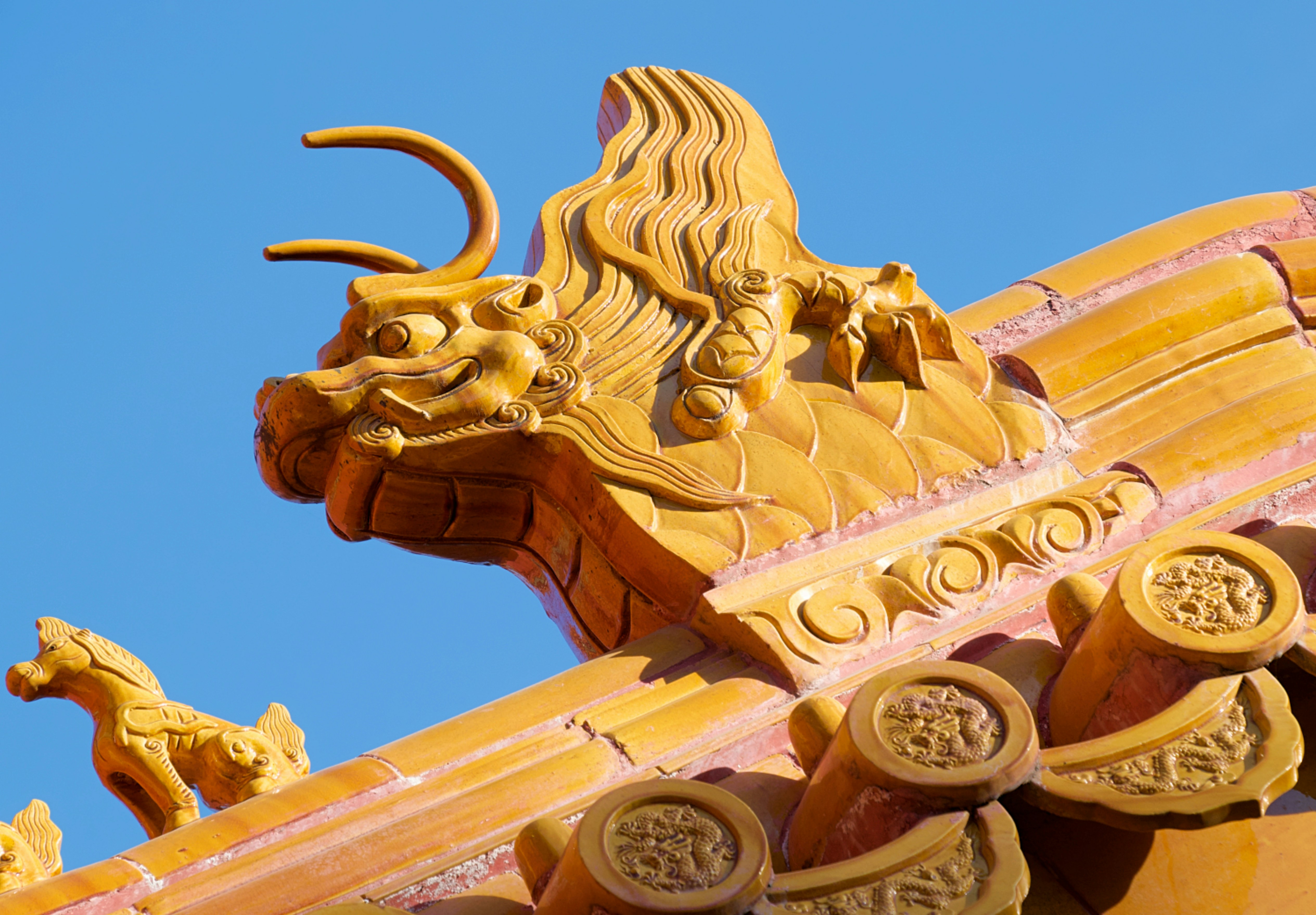 金色の龍が中国の寺院の屋根を飾っています。