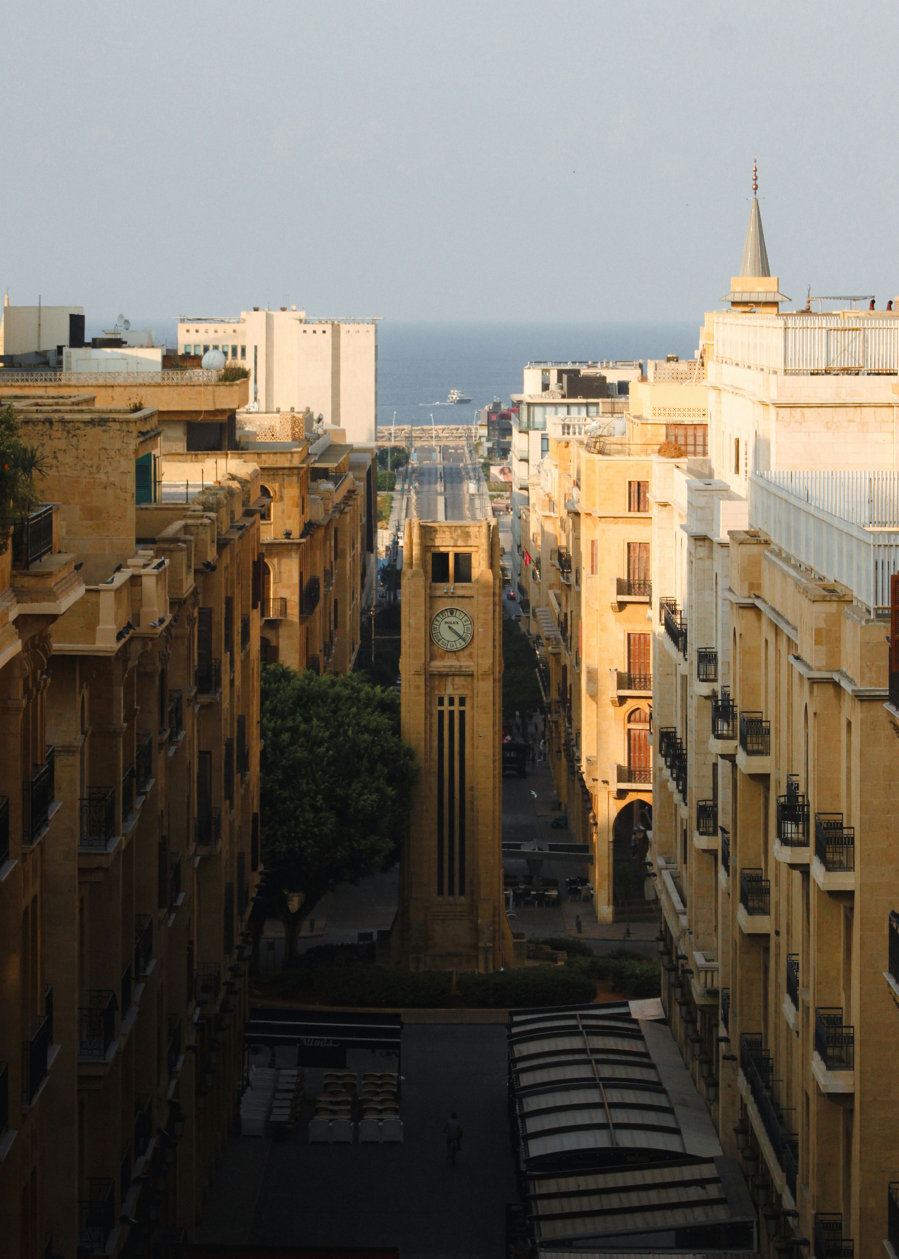 A clock tower stands amidst city buildings.