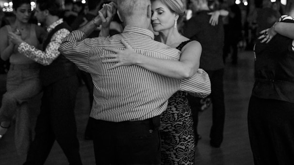 People are dancing the tango on a crowded dance floor.