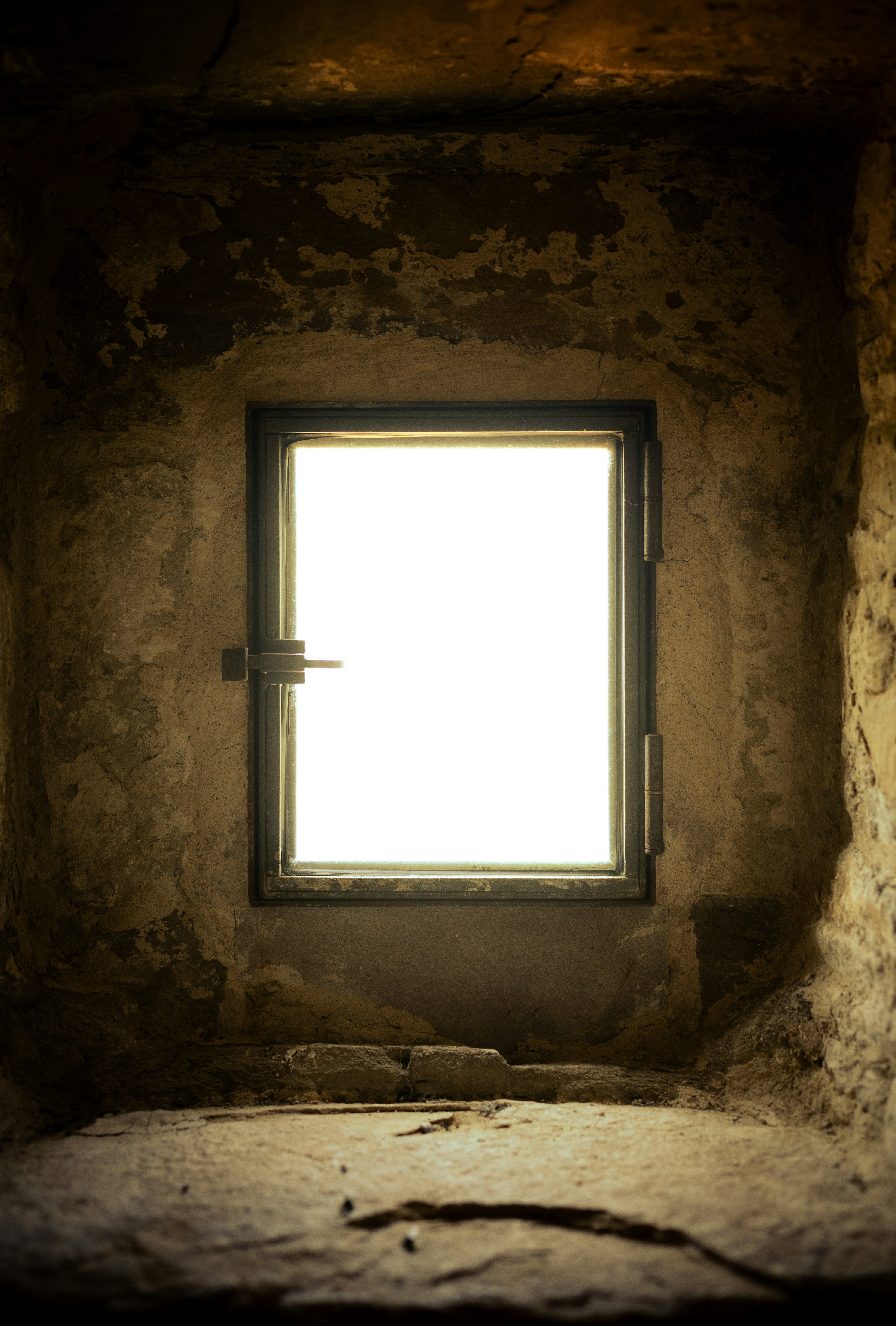 A bright window illuminates a dark, stone room.