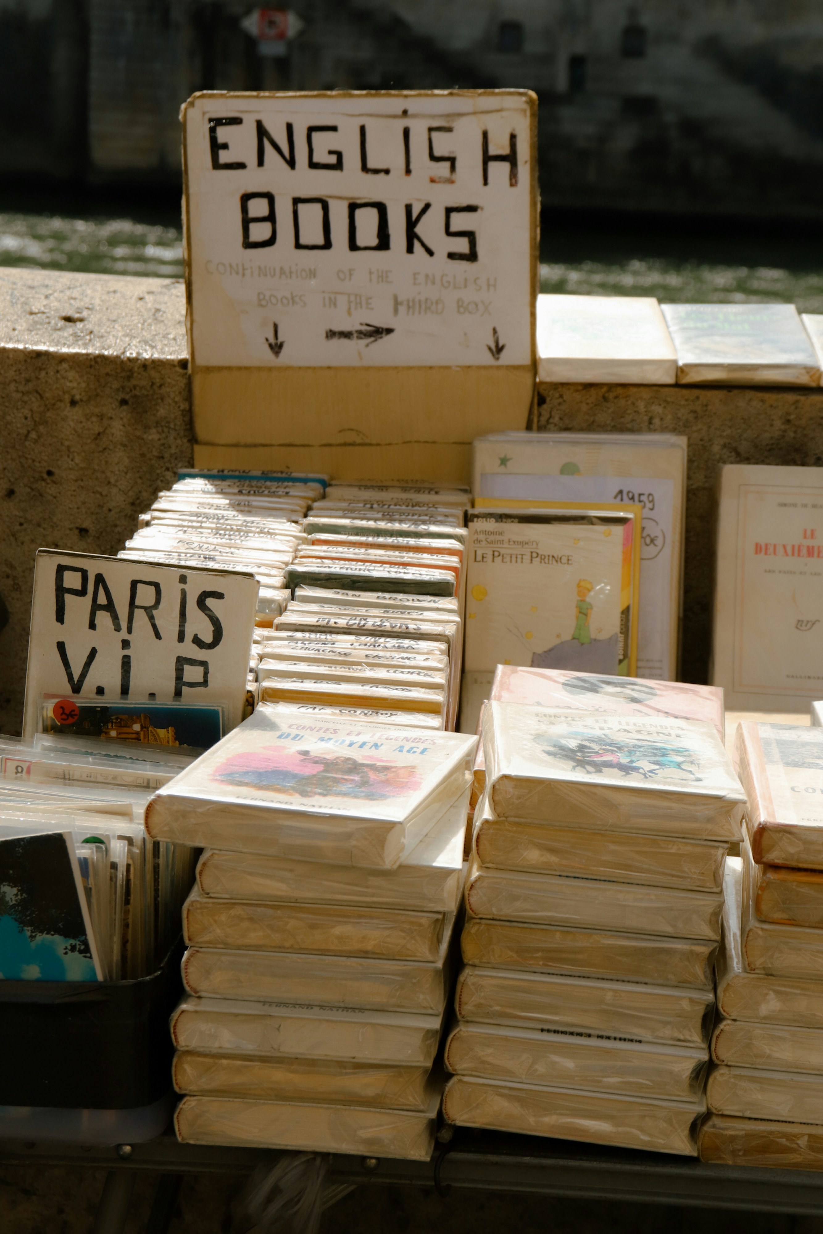 English books are for sale on a parisian stand.