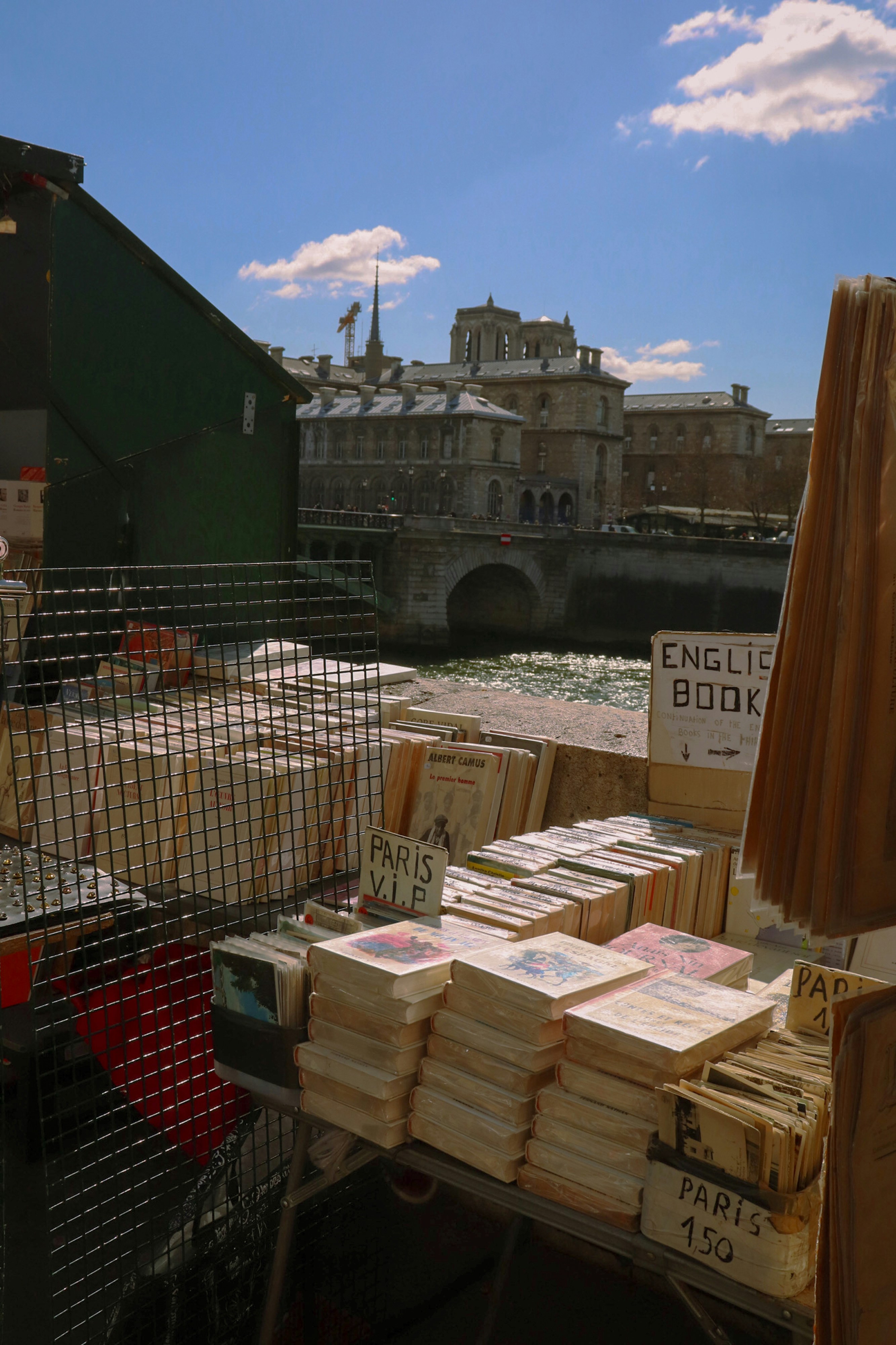 Books are for sale near a river in paris.