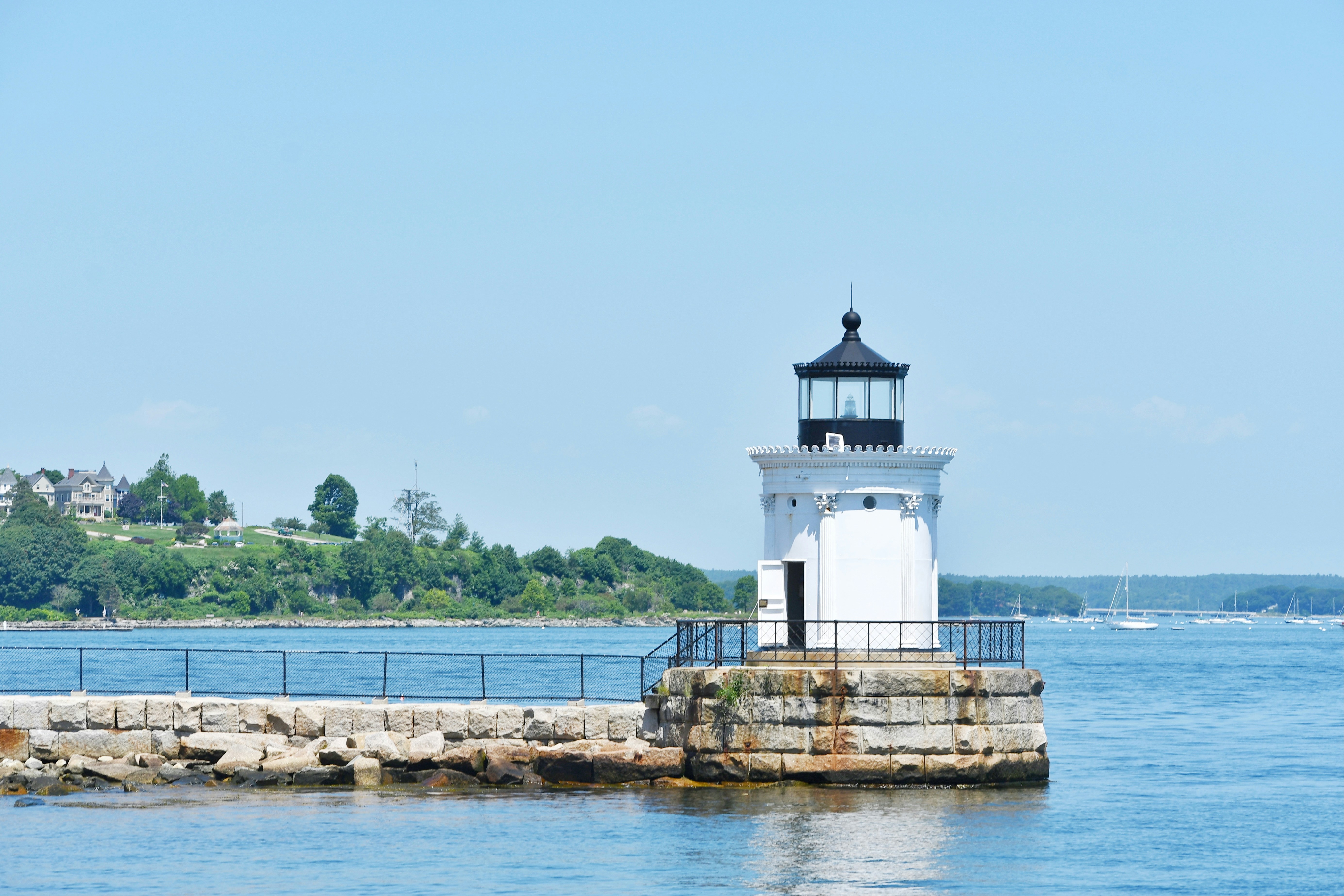 A lighthouse sits atop a jetty.