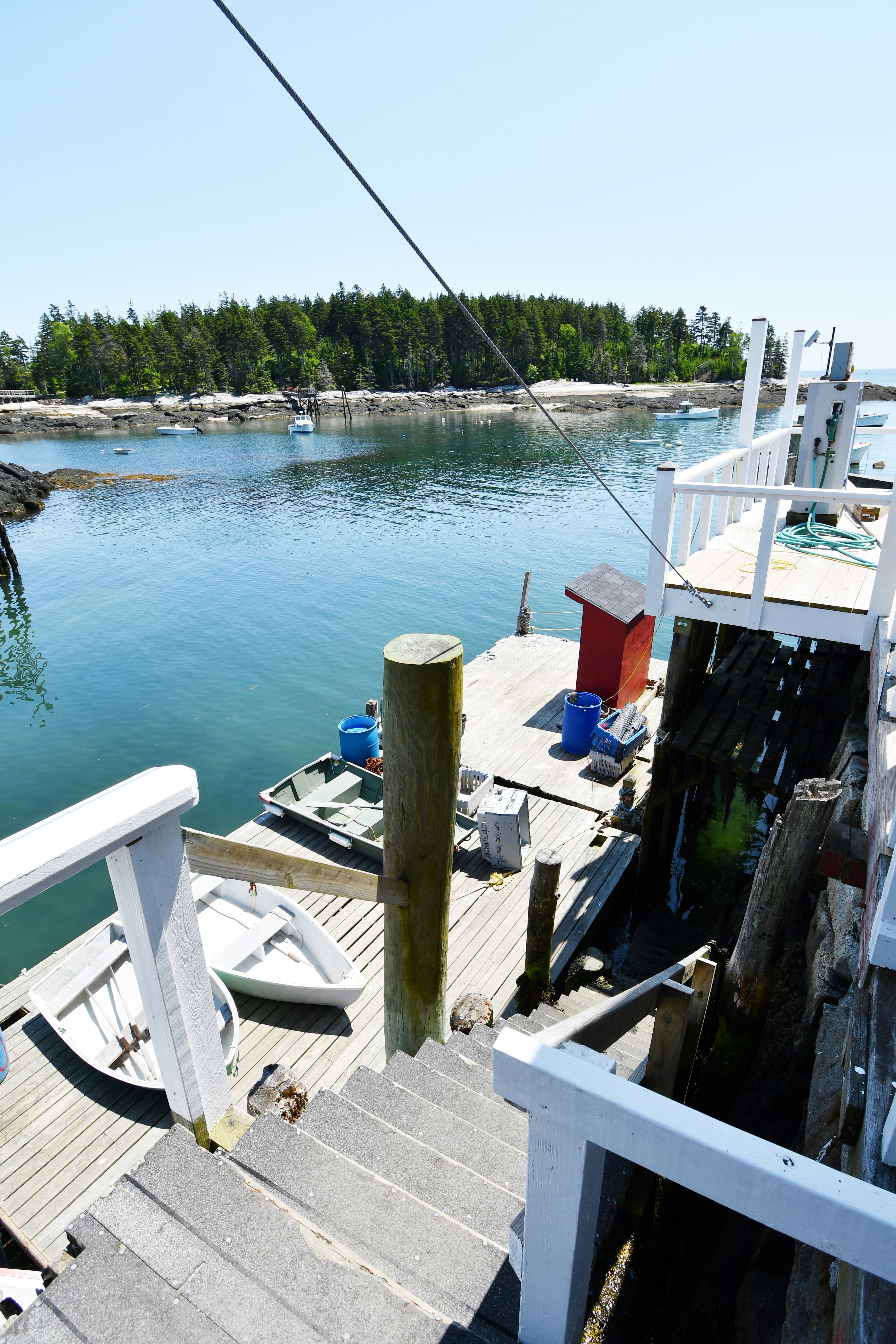 A wooden dock and a peaceful coastal view.