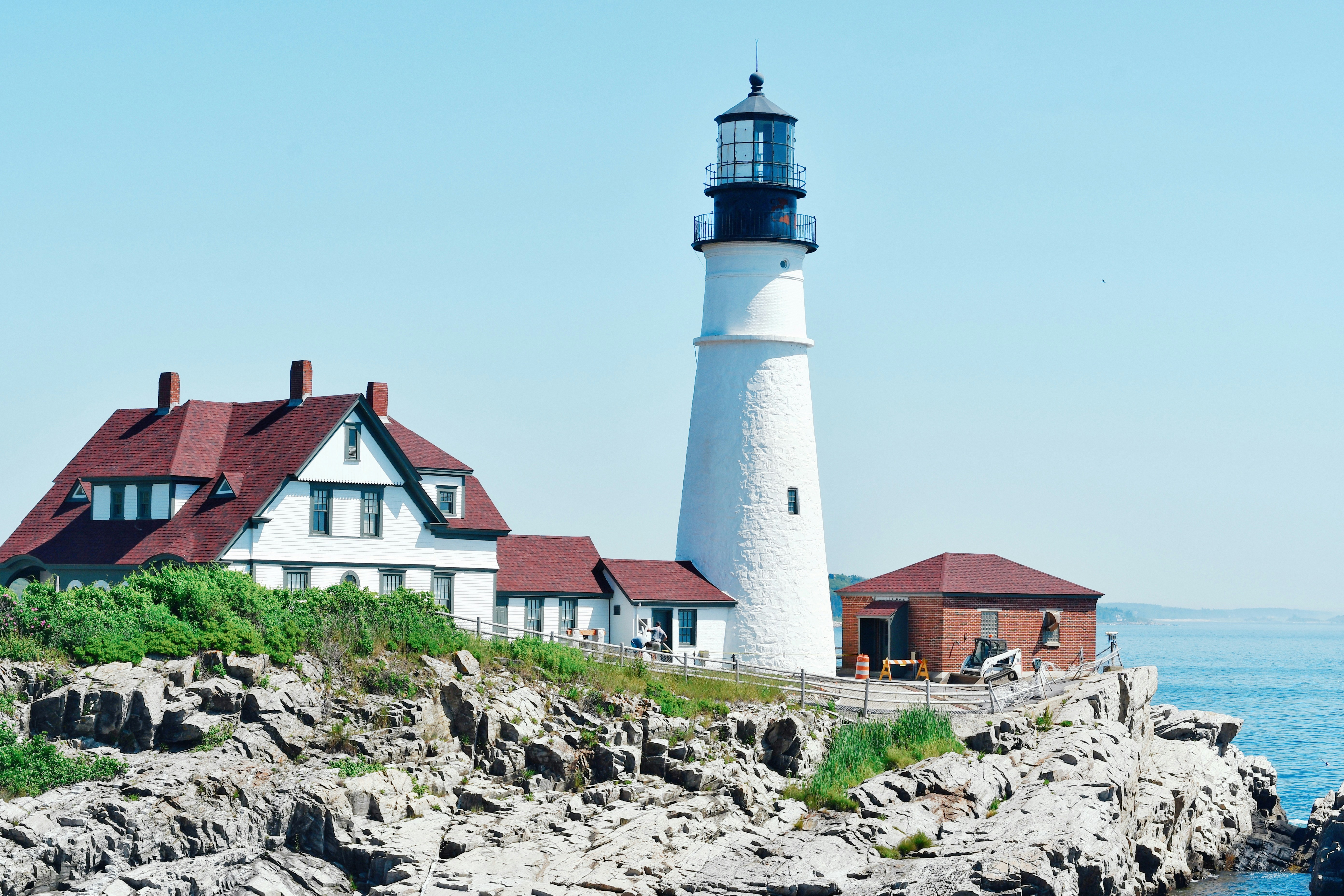 A lighthouse stands tall on rocky coastline.