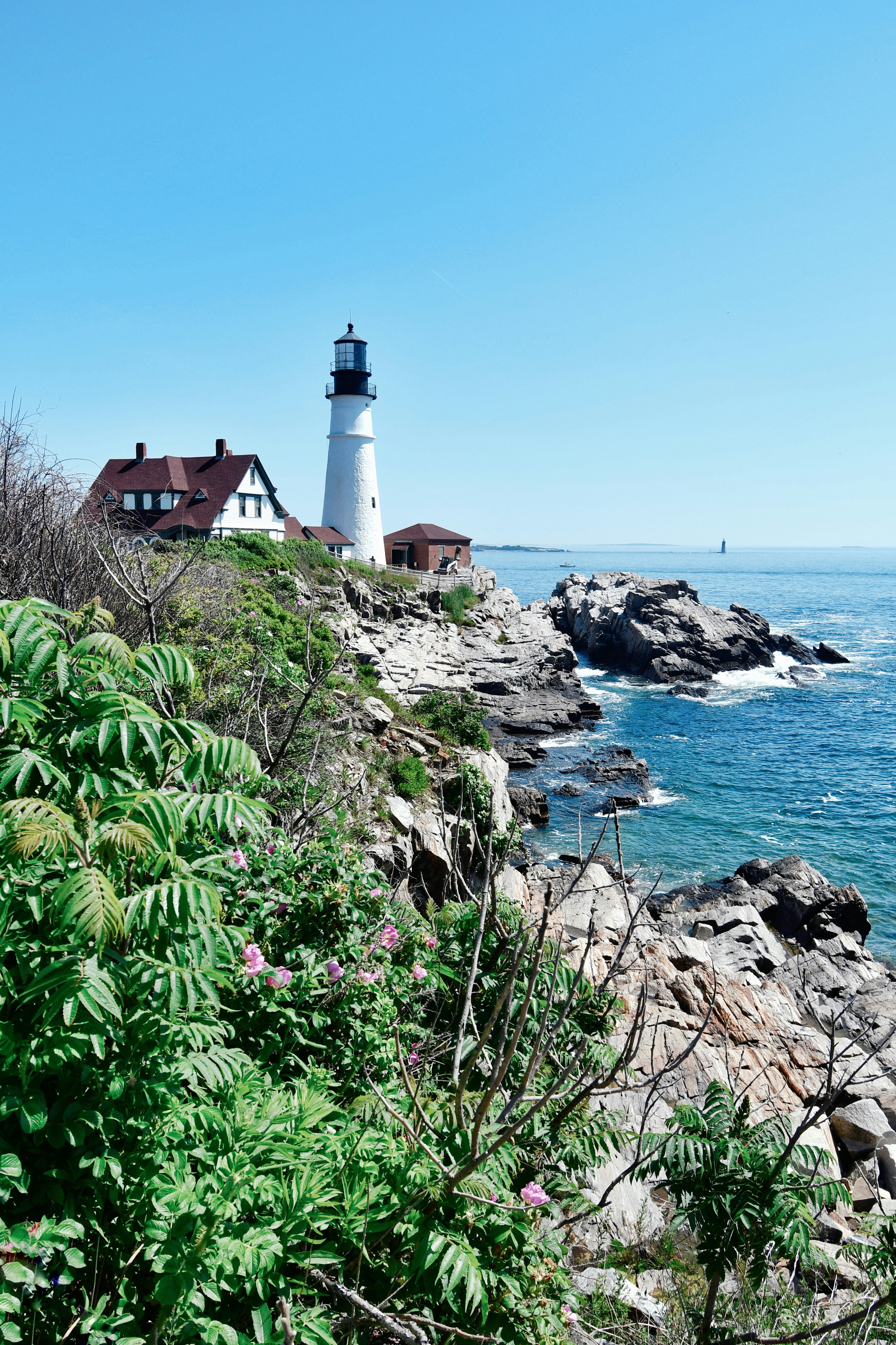 A lighthouse stands on a rocky coast.