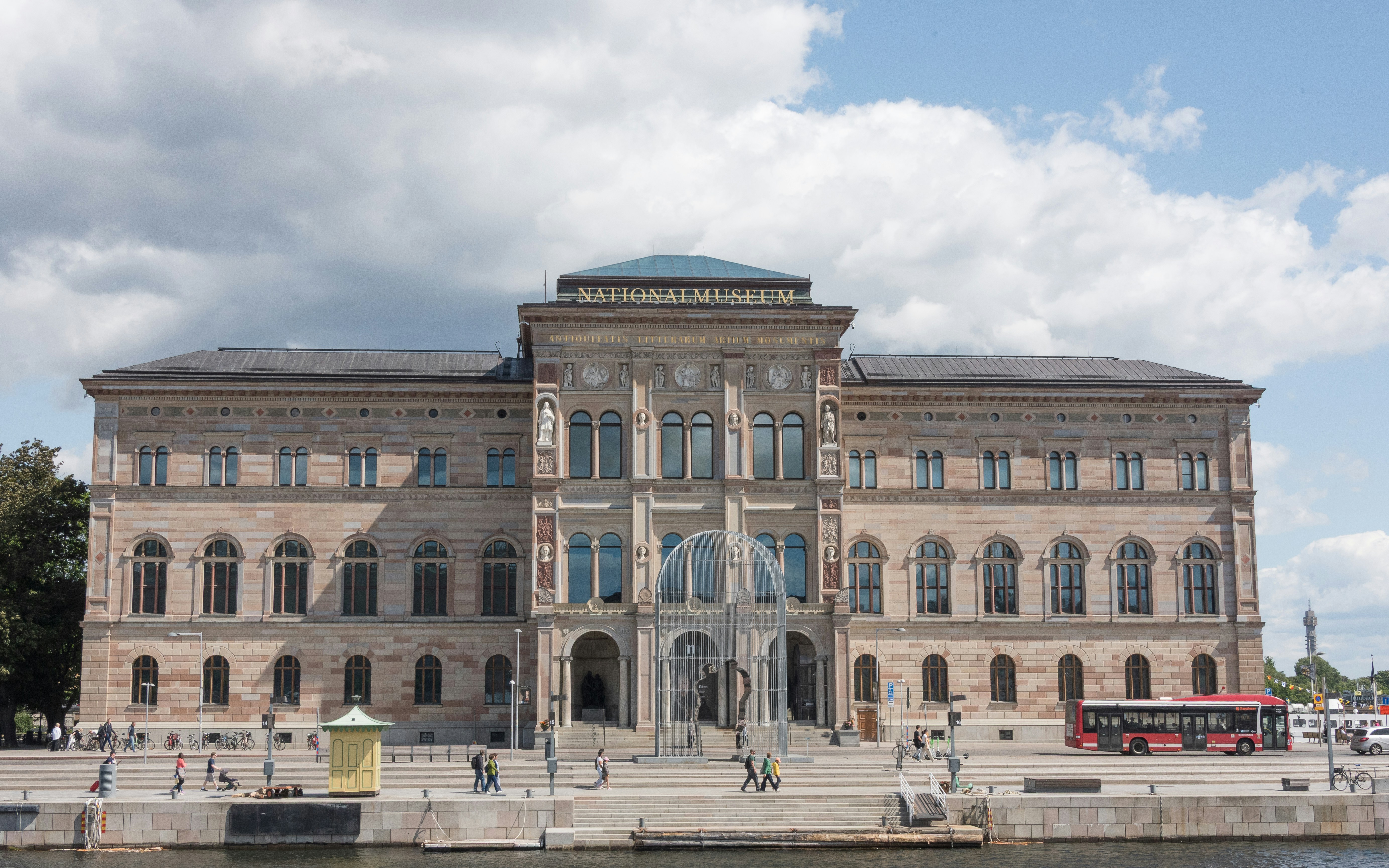 A large, ornate building with a bus in front.