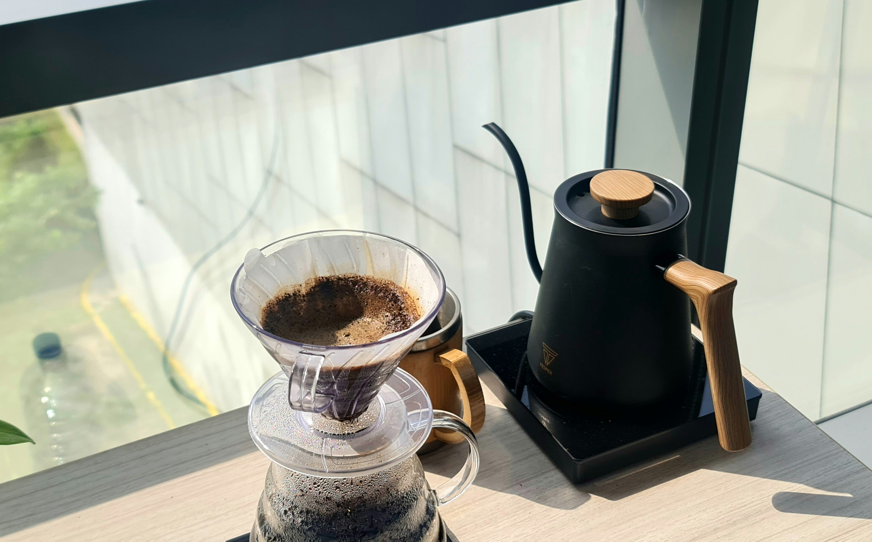 Brewing coffee with a kettle by the window.