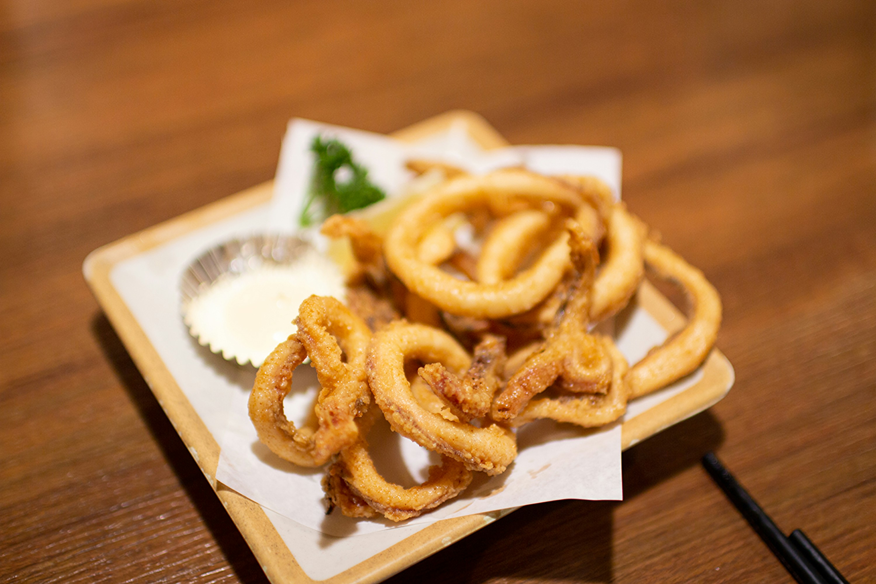 Here is a caption: fried calamari served with dipping sauce.