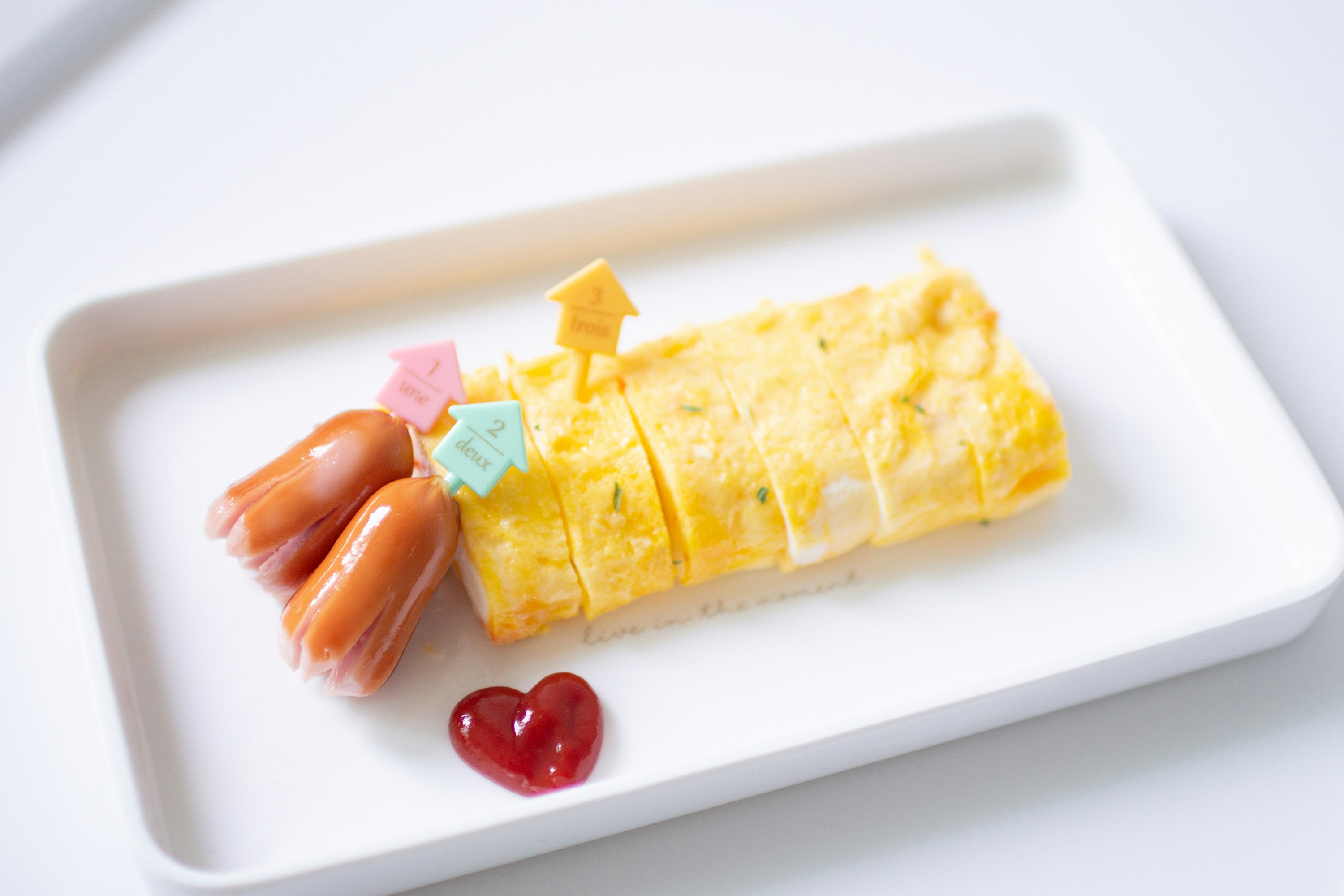 A plate features eggs, sausage and a heart.