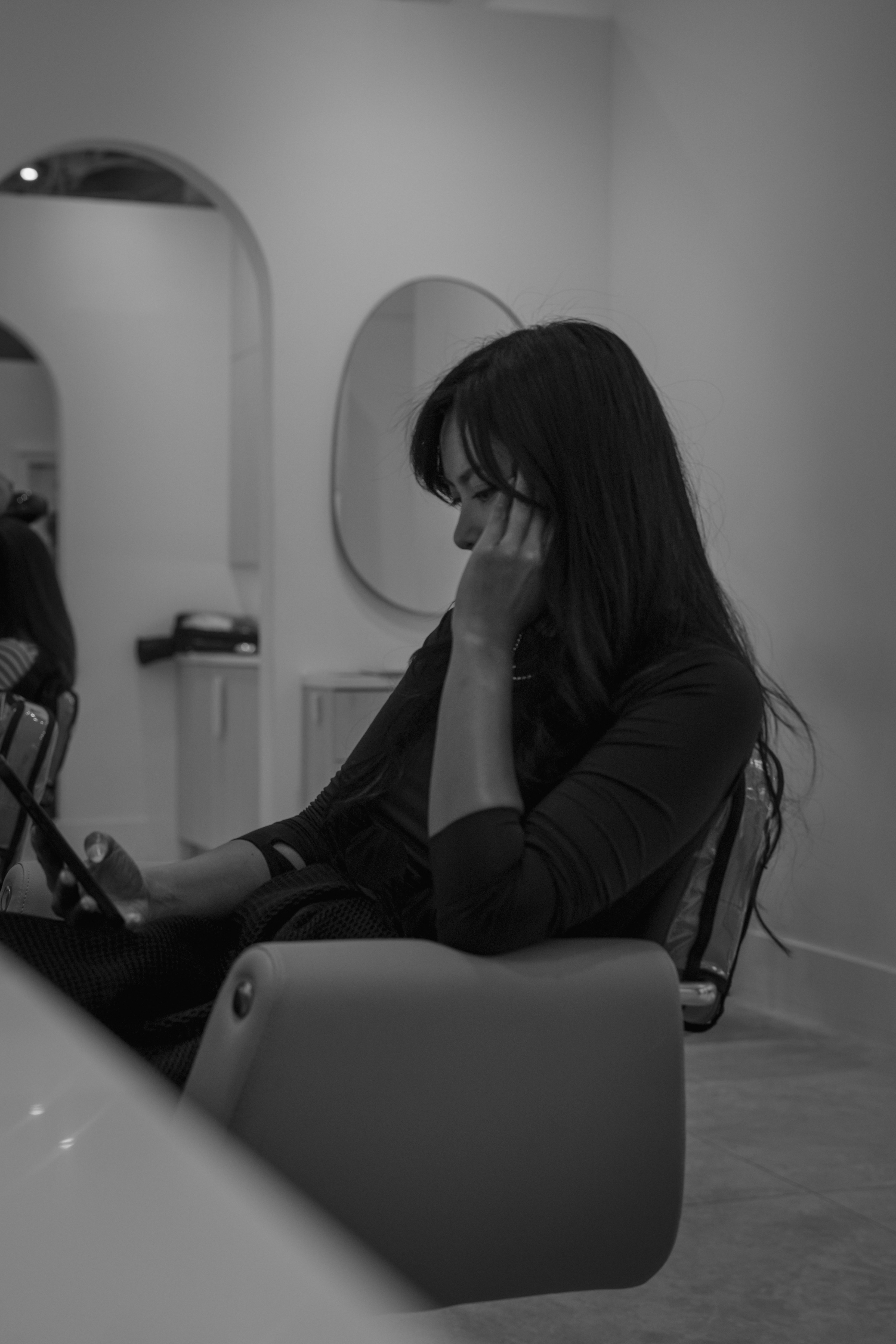 Mulher senta-se e usa um tablet em um salão de beleza.