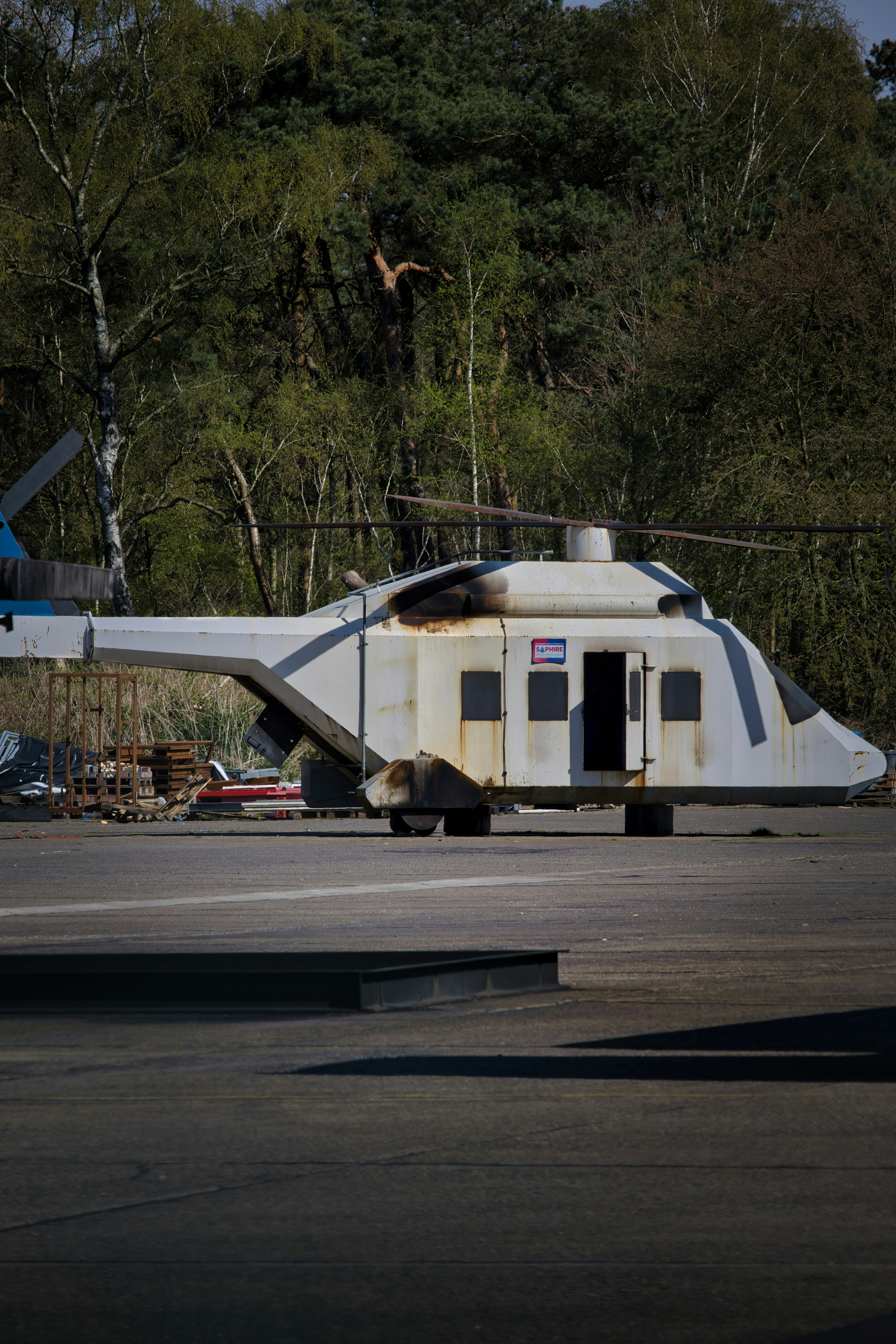 A white helicopter stands on a gray surface.