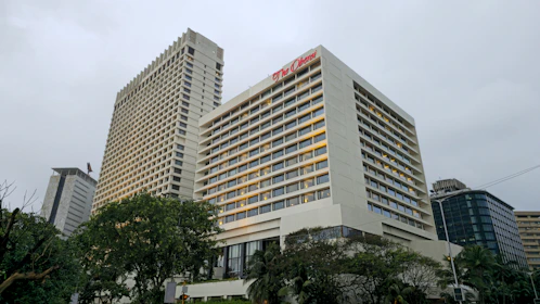 Tall buildings sit beneath a cloudy sky.
