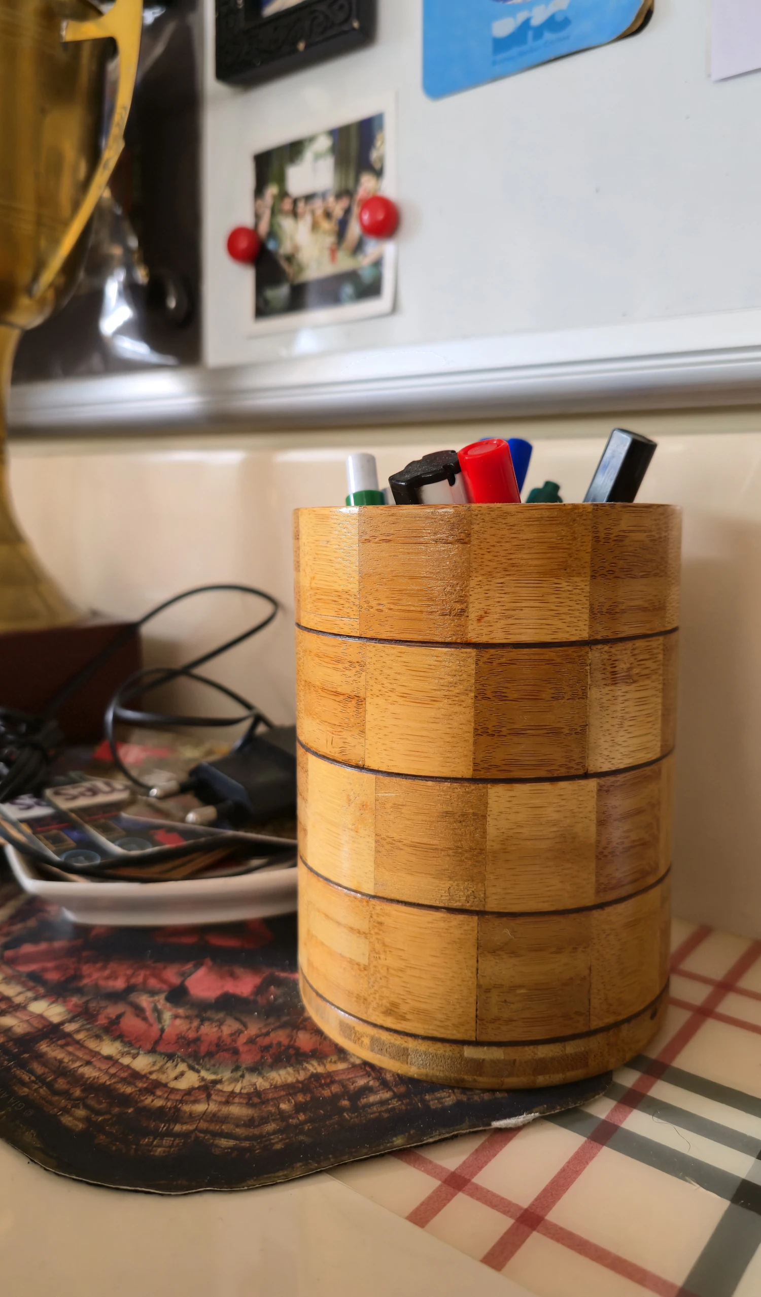 Pens and pencils laid out in an oak holder on the shop counter