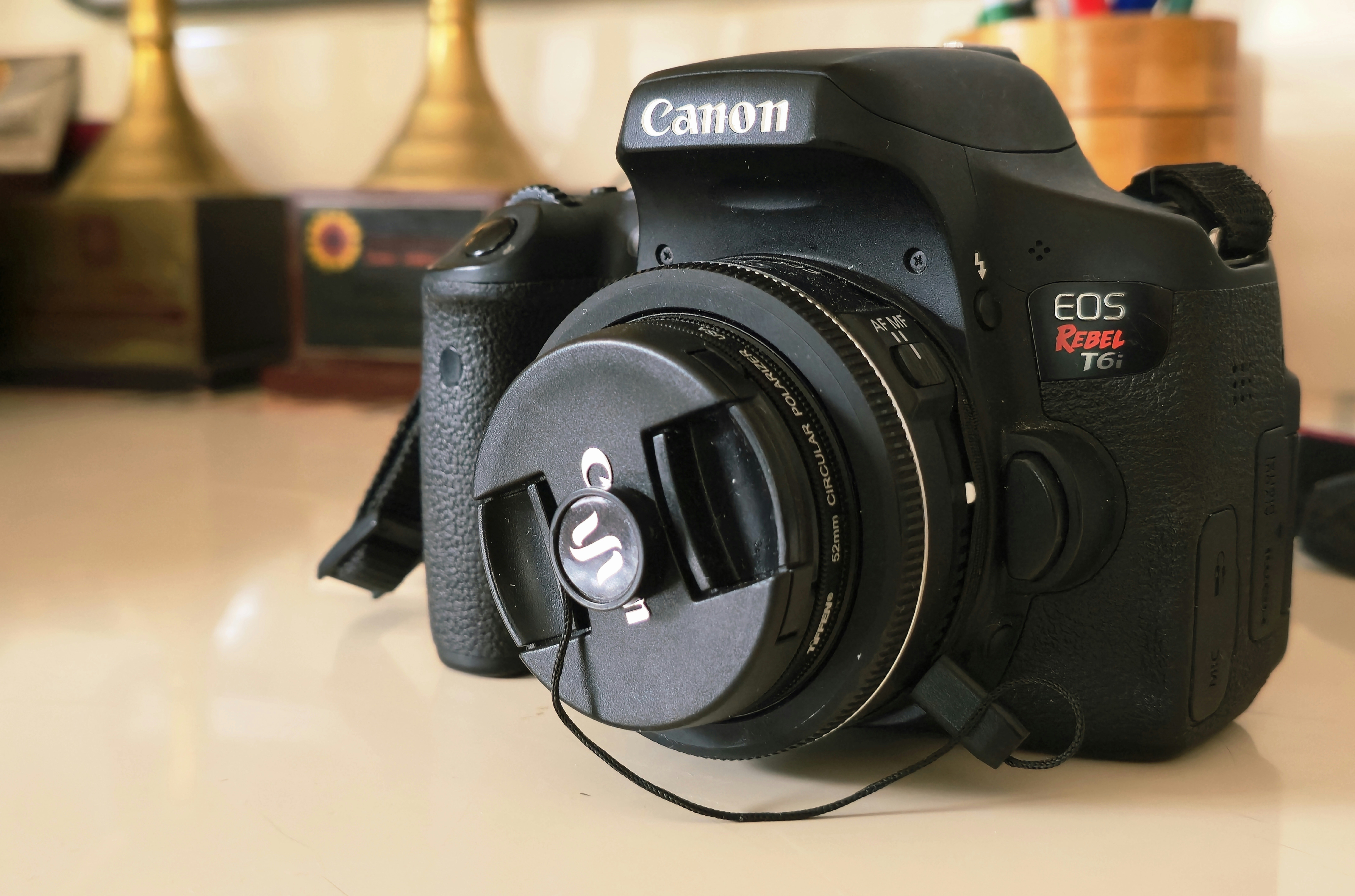 A canon camera rests on a white surface.