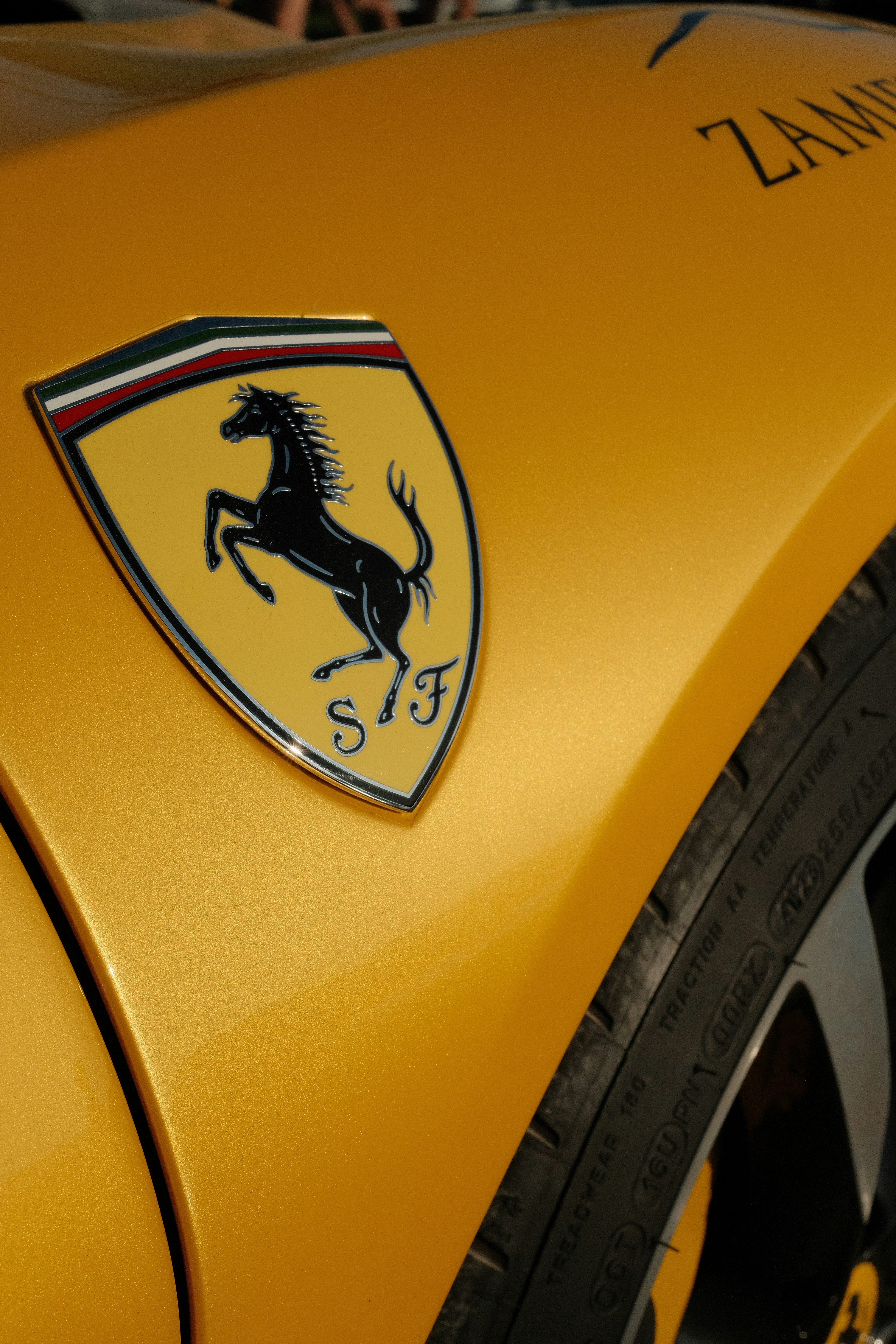 A ferrari badge is displayed on a yellow car. photo – Free Car Image on ...