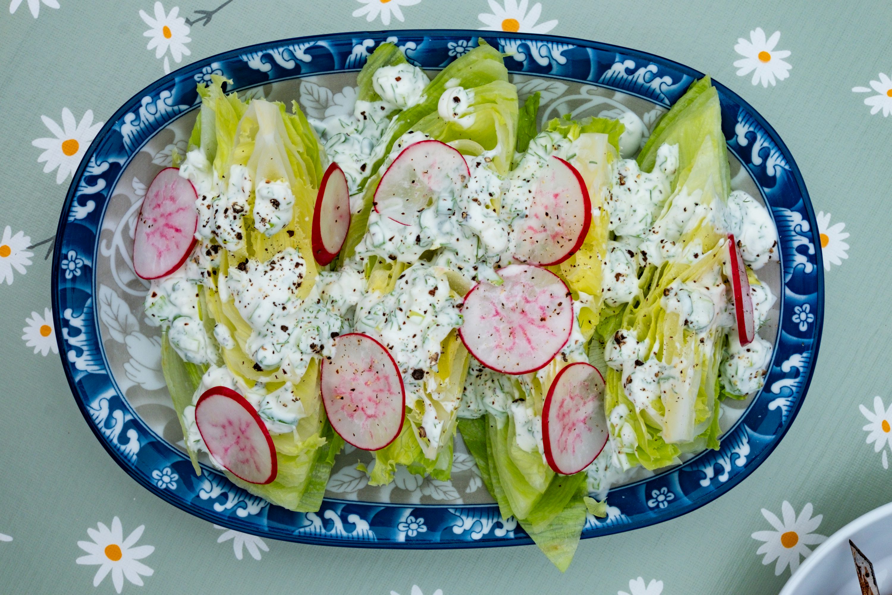 A fresh salad with radishes and dressing is pictured.