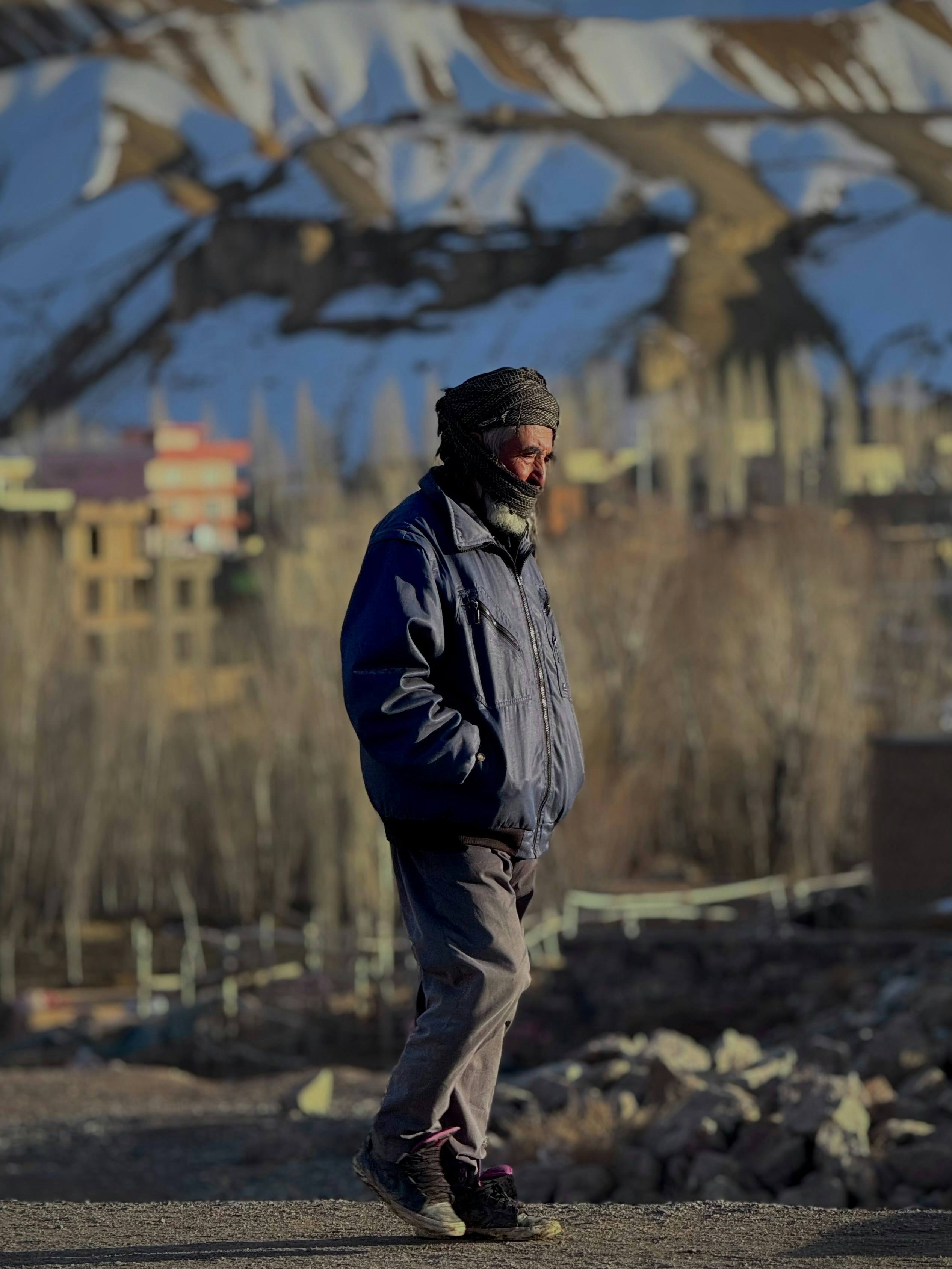 Ein Mann steht auf einer Straße mit Berghintergrund.