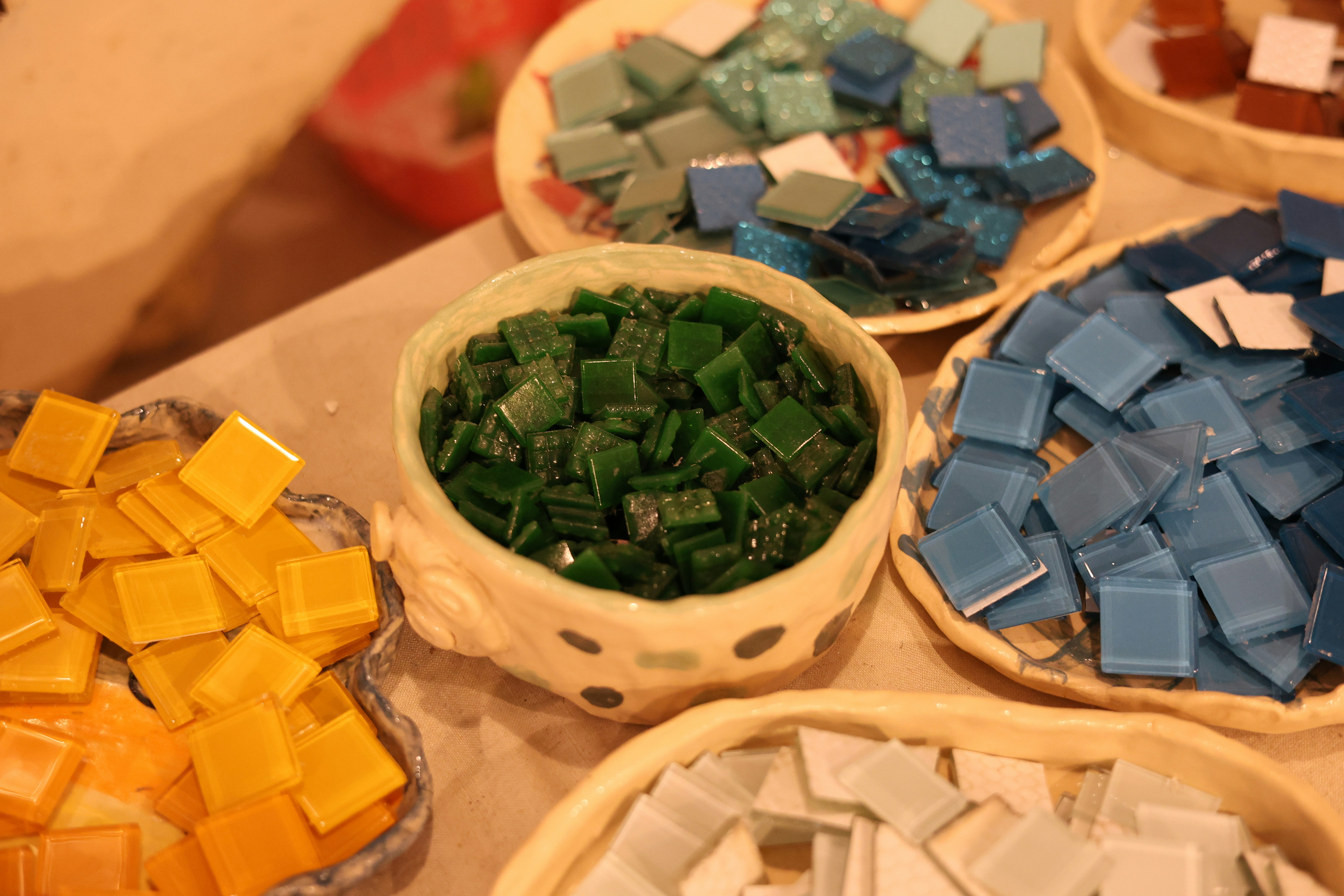Colorful mosaic tiles are arranged in decorative bowls.