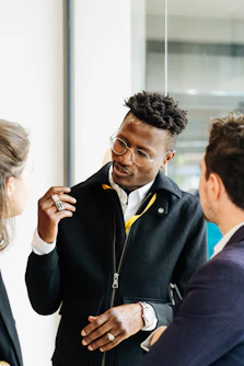 Three people are engaged in a friendly conversation.