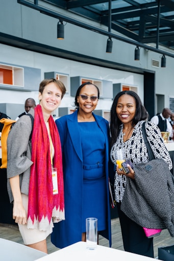 Three smiling women pose for a photograph.
