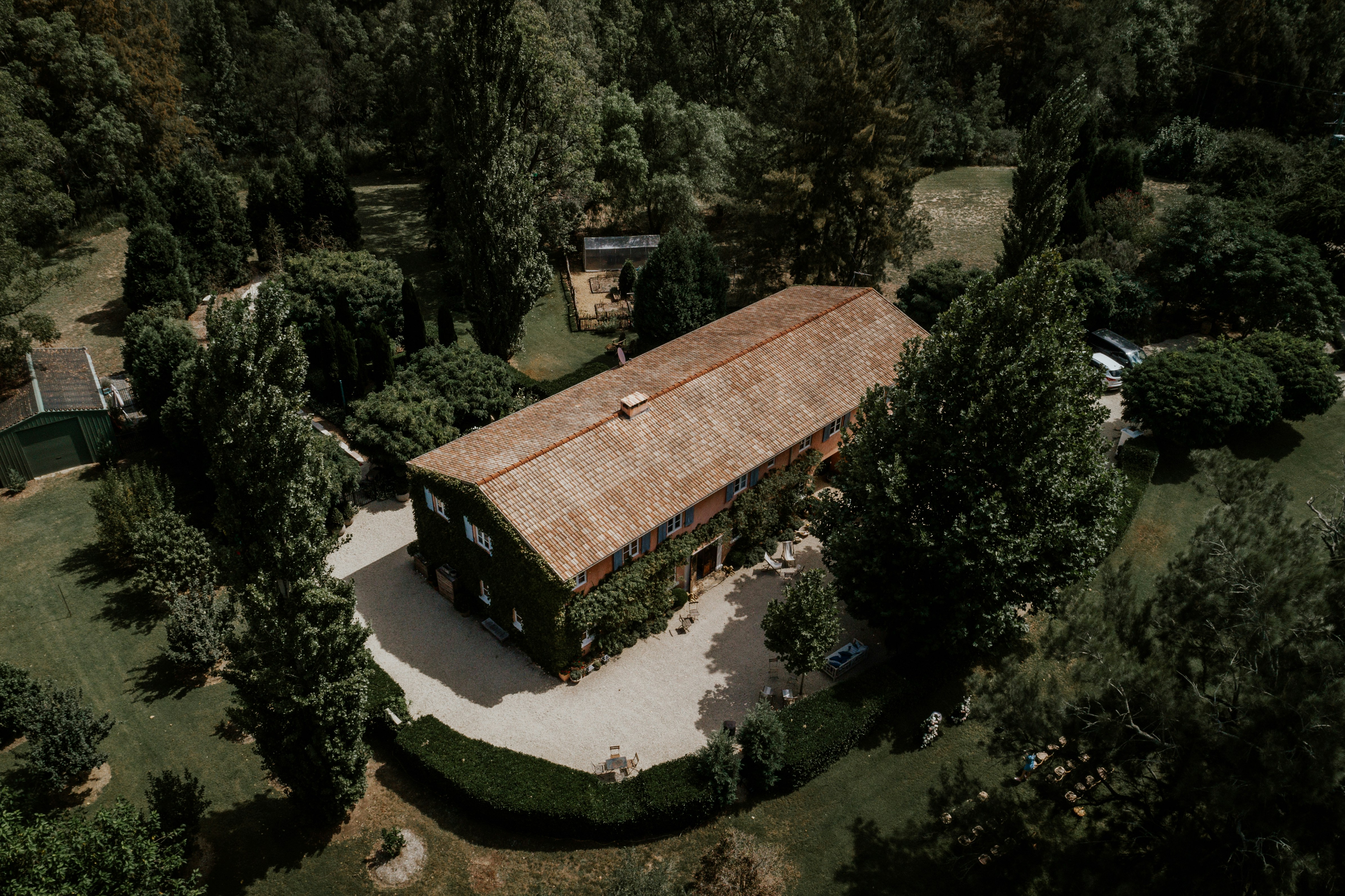 An aerial view of a house in the woods.